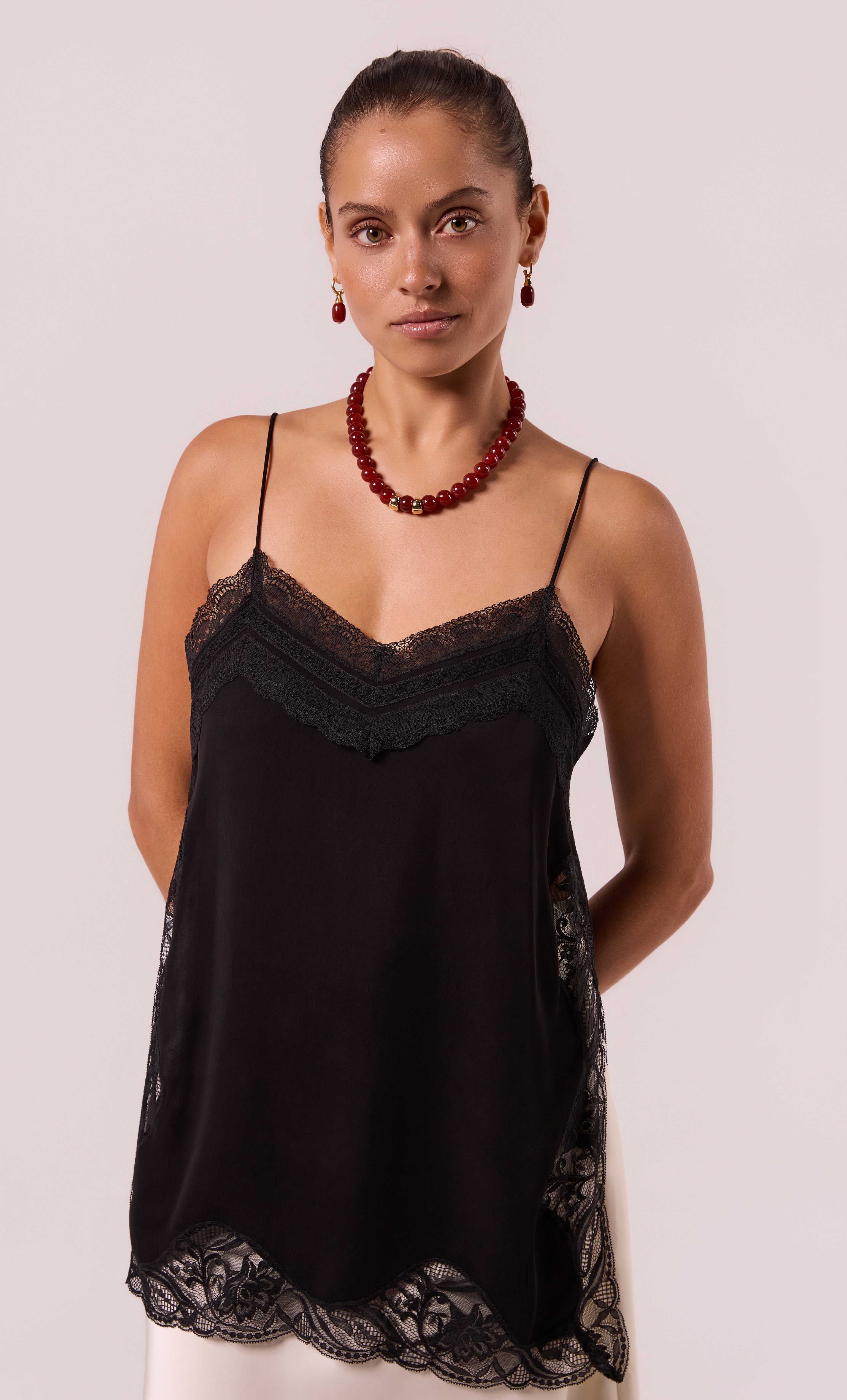 Bold red carnelian agate stone bead necklace paired with gold fill accents worn with black lace-trimmed camisole.