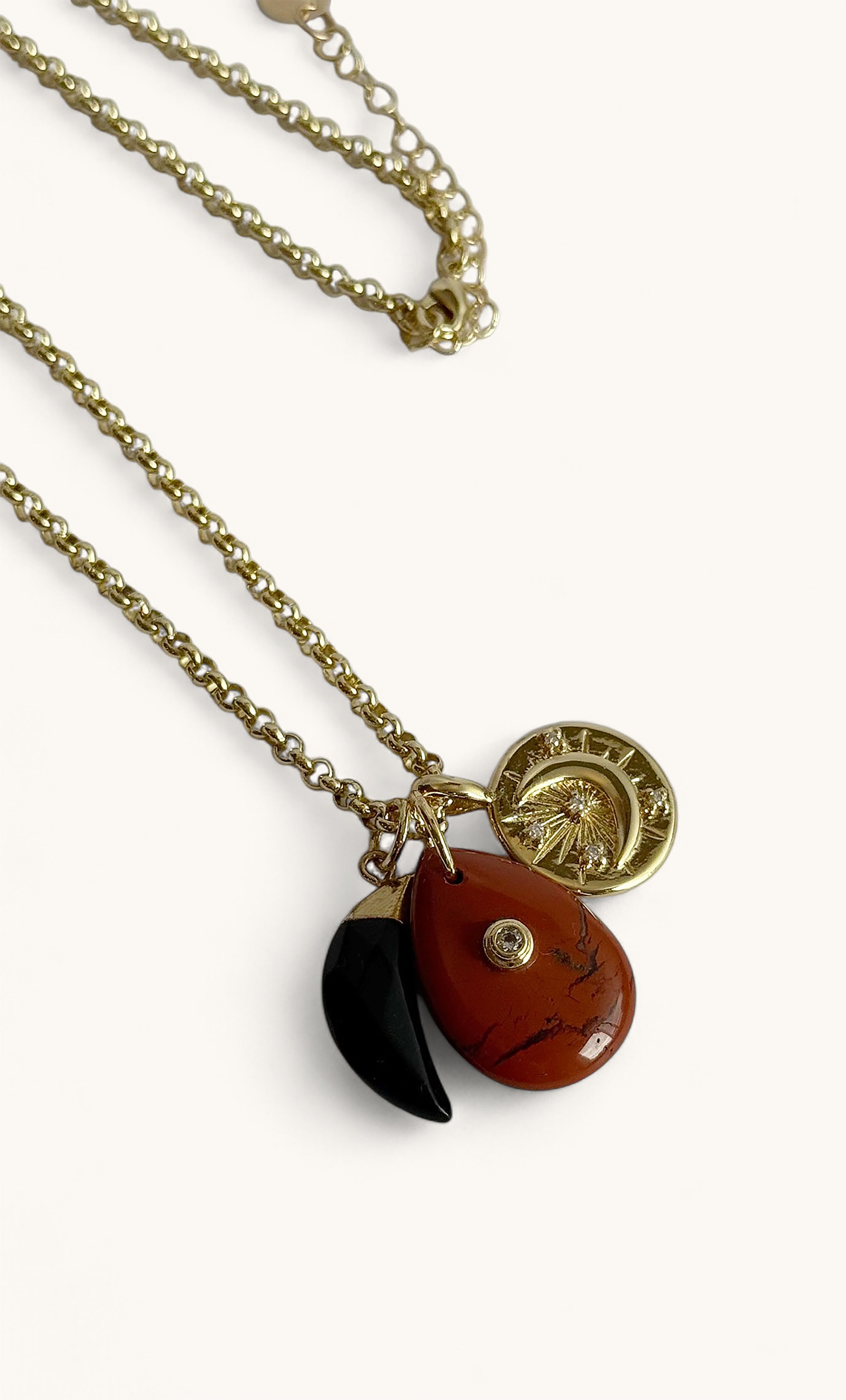 Tunik gold fill rolo chain necklace with carnelian charm, black crescent, and gold pendant.