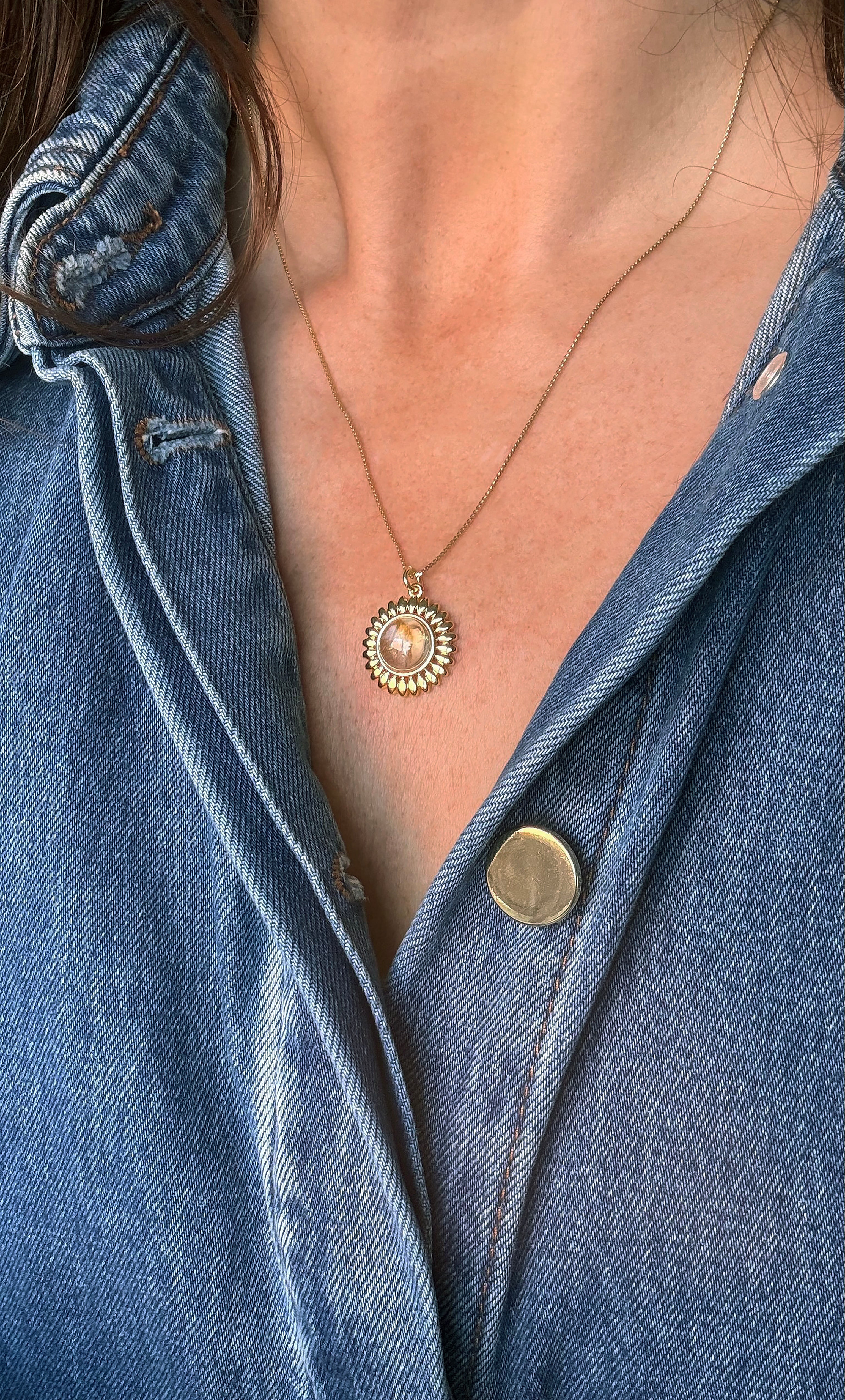 14K gold fill sun talisman pendant necklace with moonstone center, worn with denim shirt.