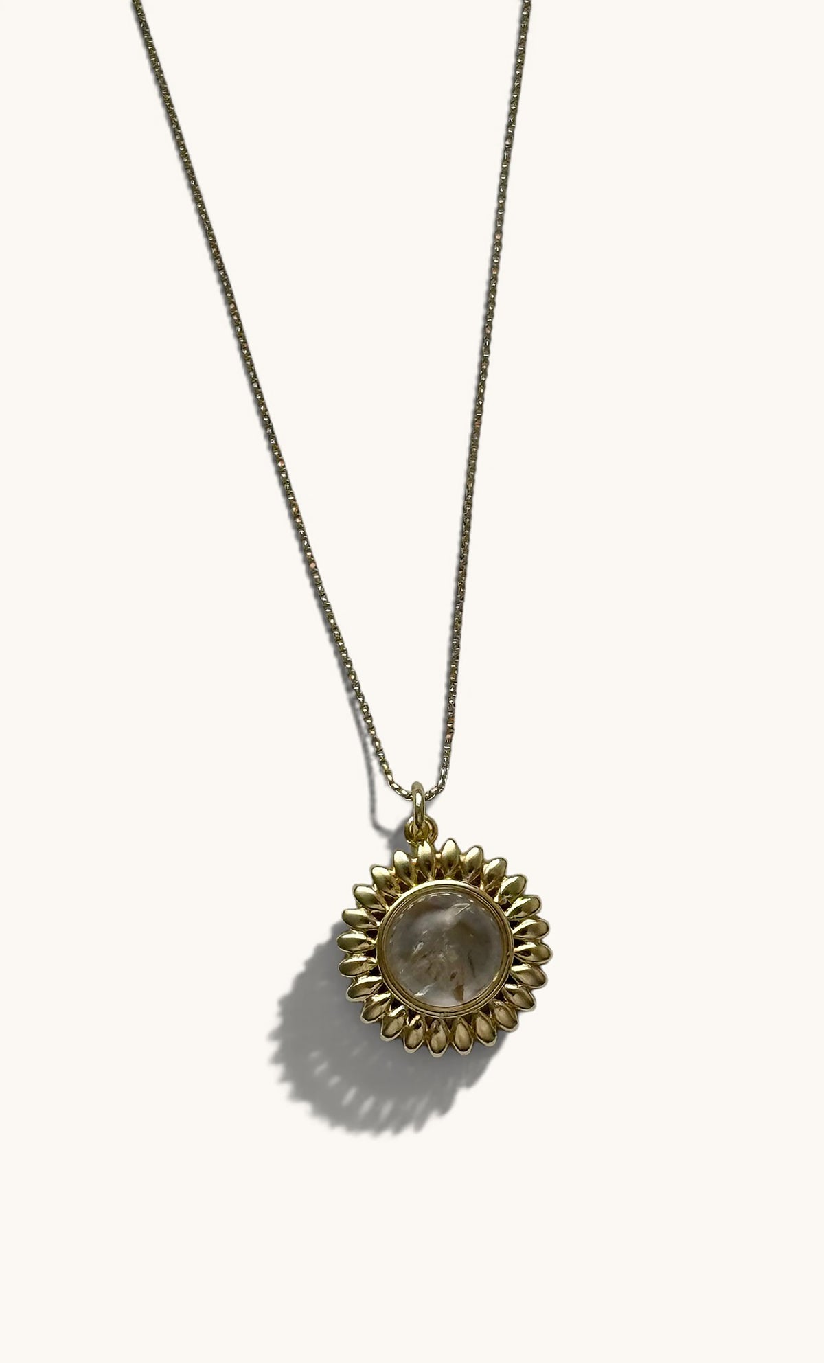14K gold fill necklace with sun-shaped talisman and round moonstone center pendant.