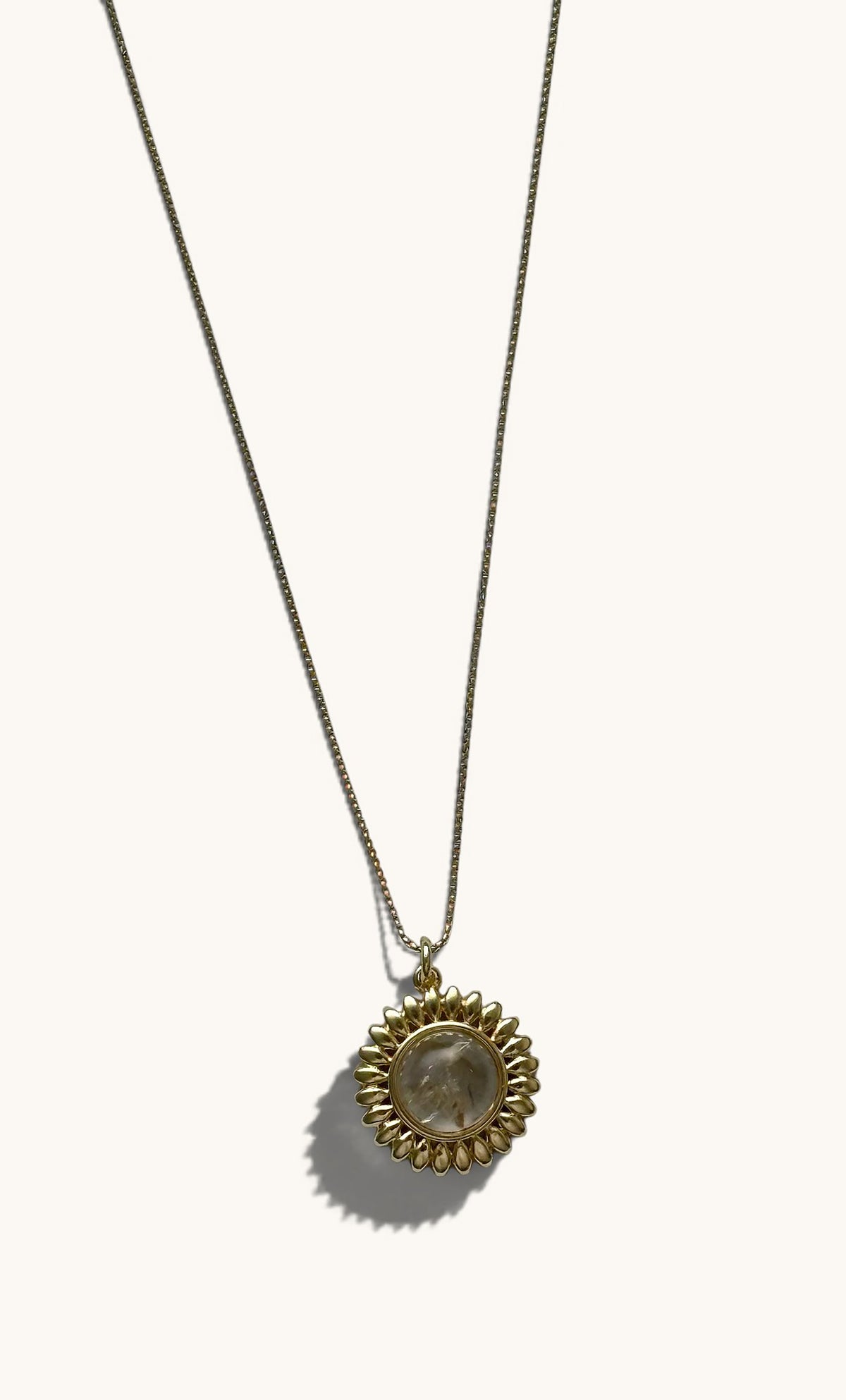 14K gold fill sun talisman pendant necklace with a glowing moonstone center on a fine gold chain.