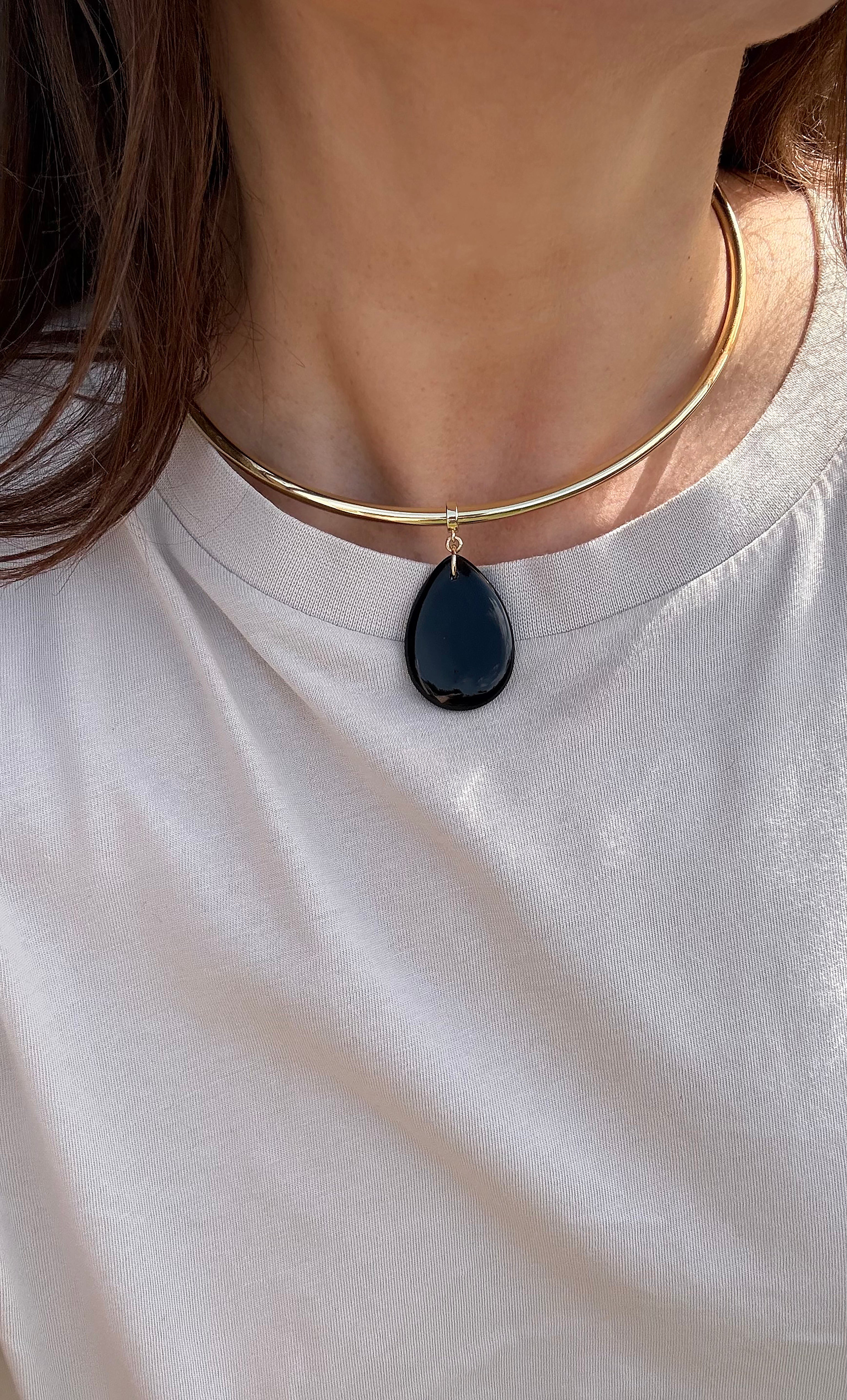 Gold fill collar necklace with teardrop-shaped dark blue agate stone pendant.