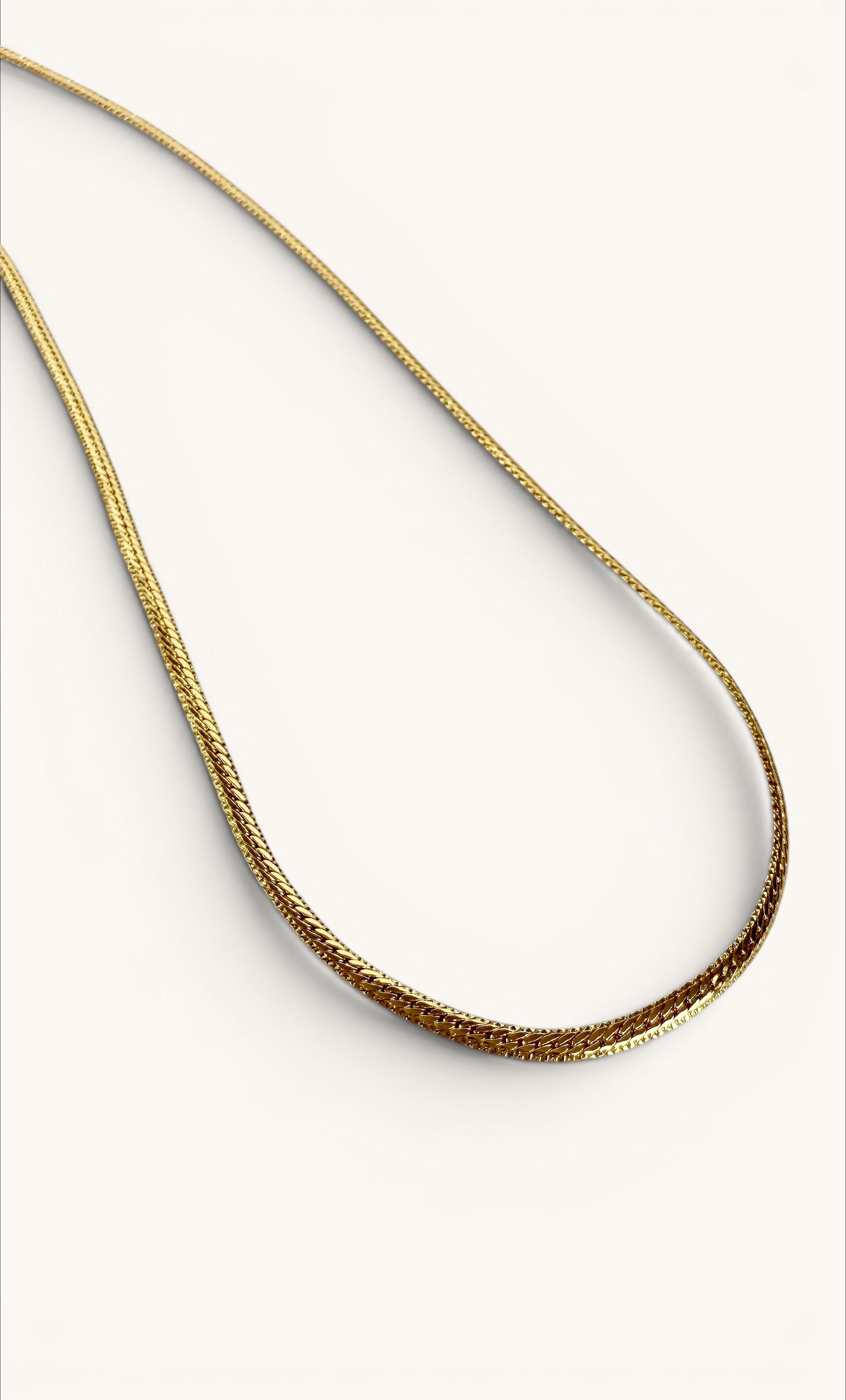 24K gold fill herringbone chain necklace with flat, closely linked design on neutral background.