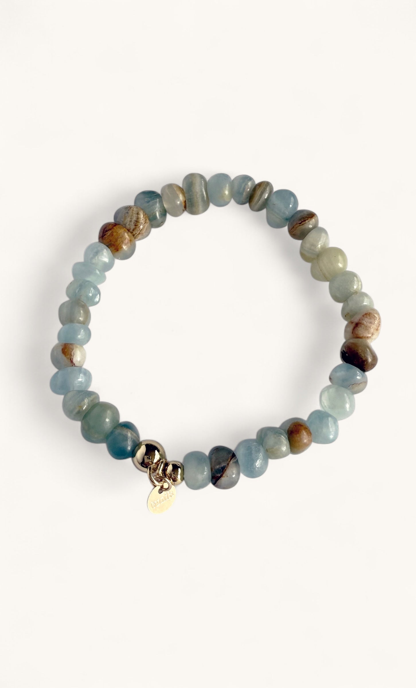 Light blue and brown chalcedony stone beads bracelet with a small gold charm, elastic design.