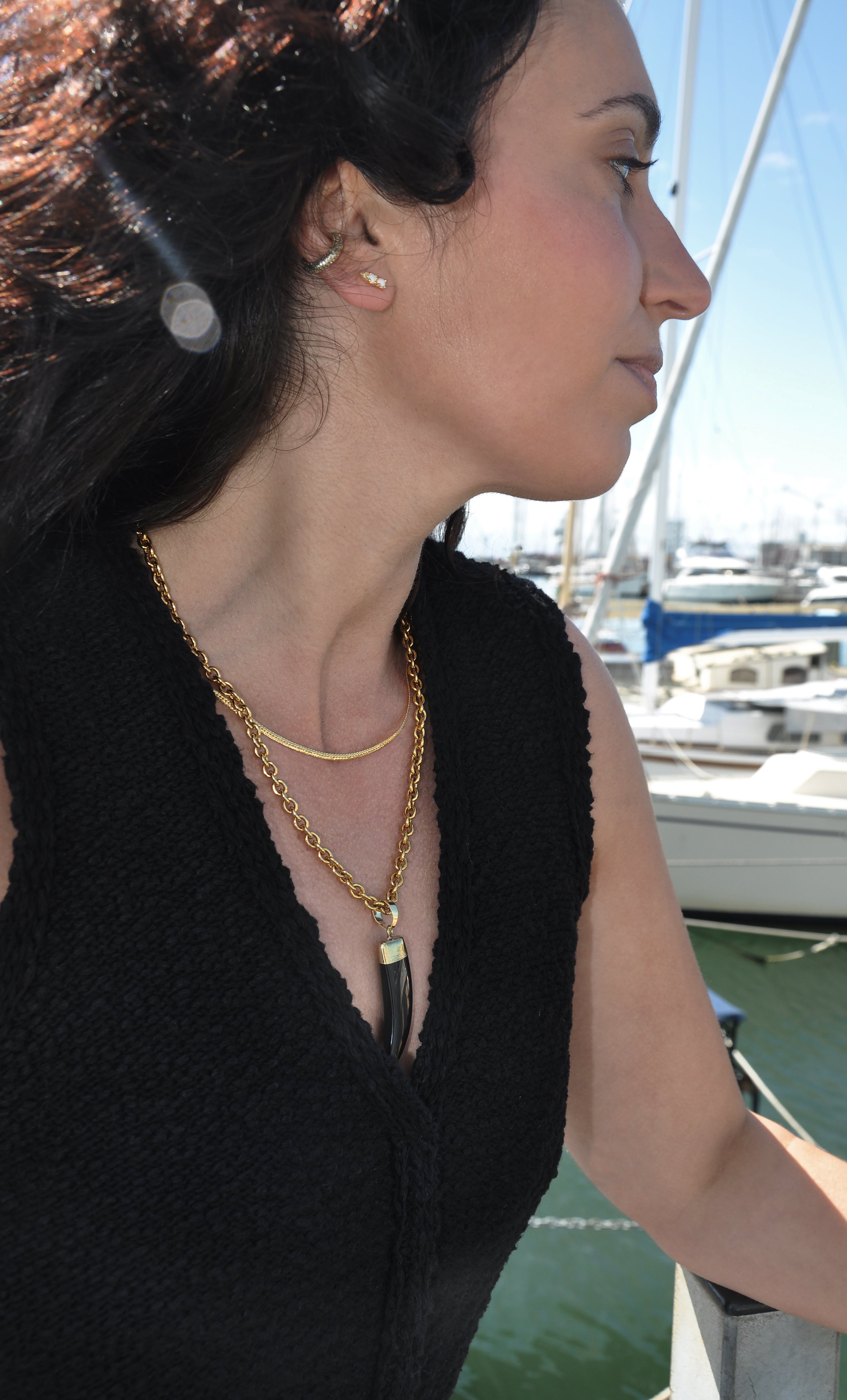 White opal arrow stud earrings in gold fill by Tunik the label, paired with layered gold necklace jewelry gifts.