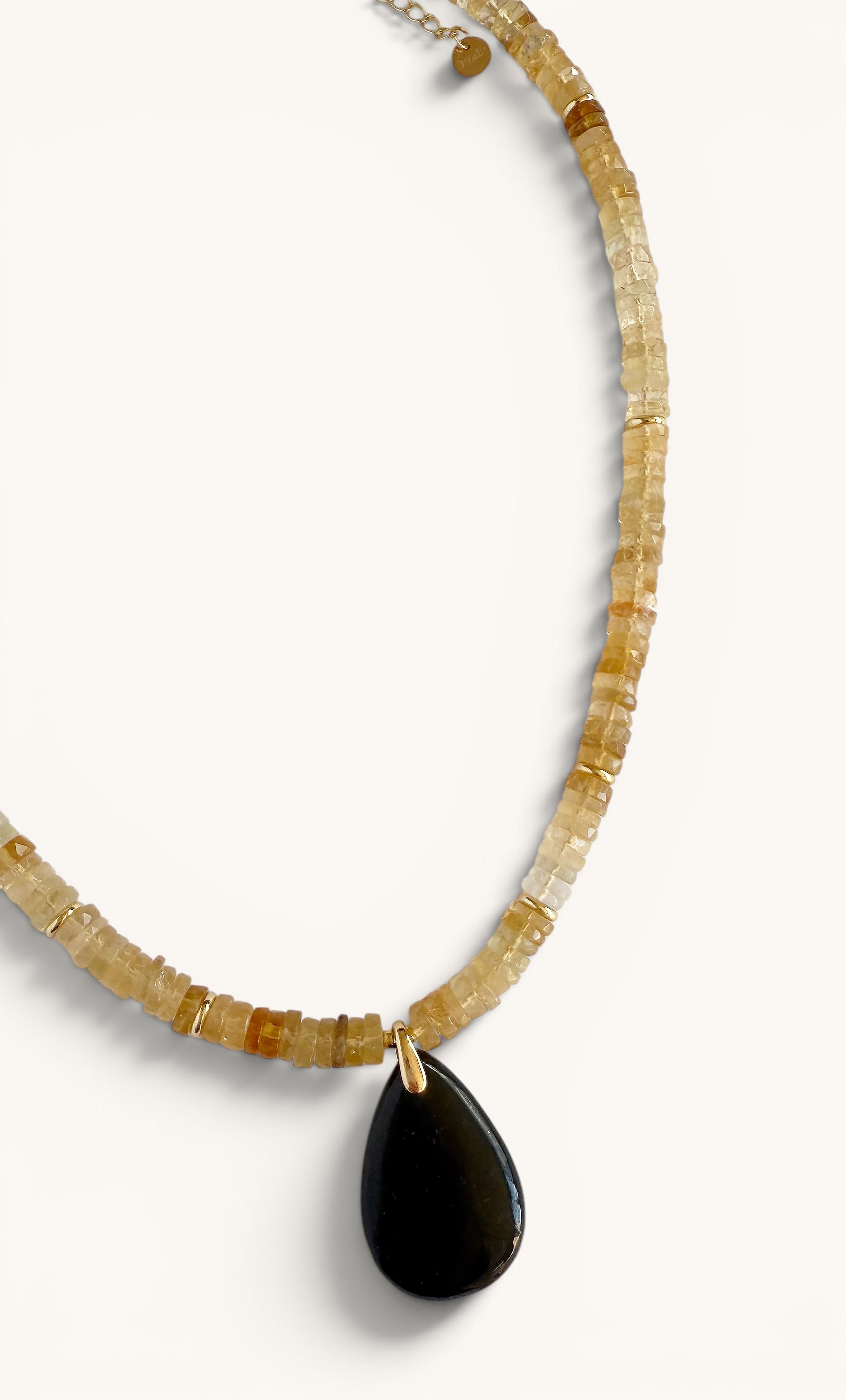 Gold-fill heishi bead necklace with a teardrop-shaped black shungite carved pendant.