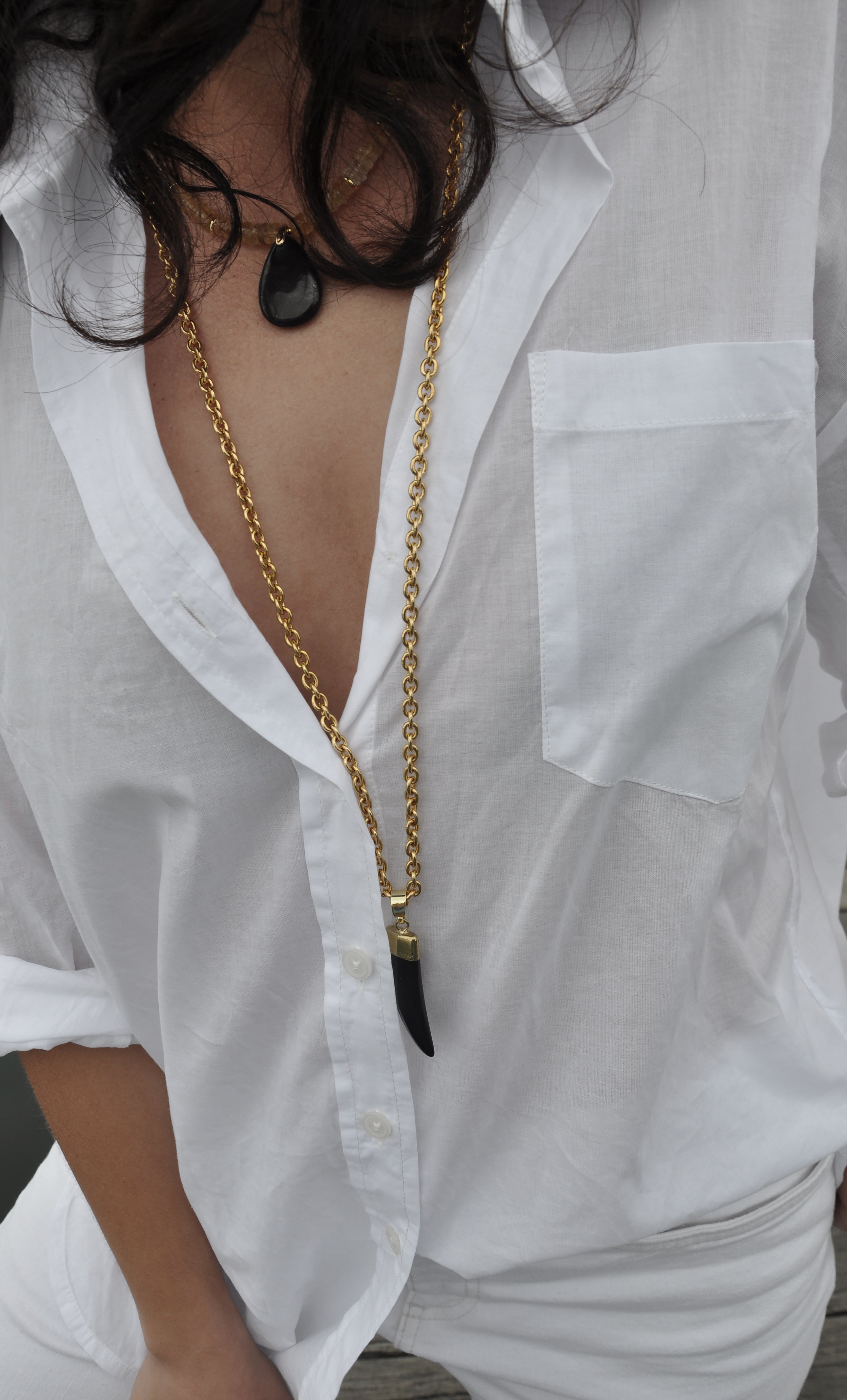 Tunik gold fill necklace with carved agate horn pendant in long and short lengths layered over white shirt.