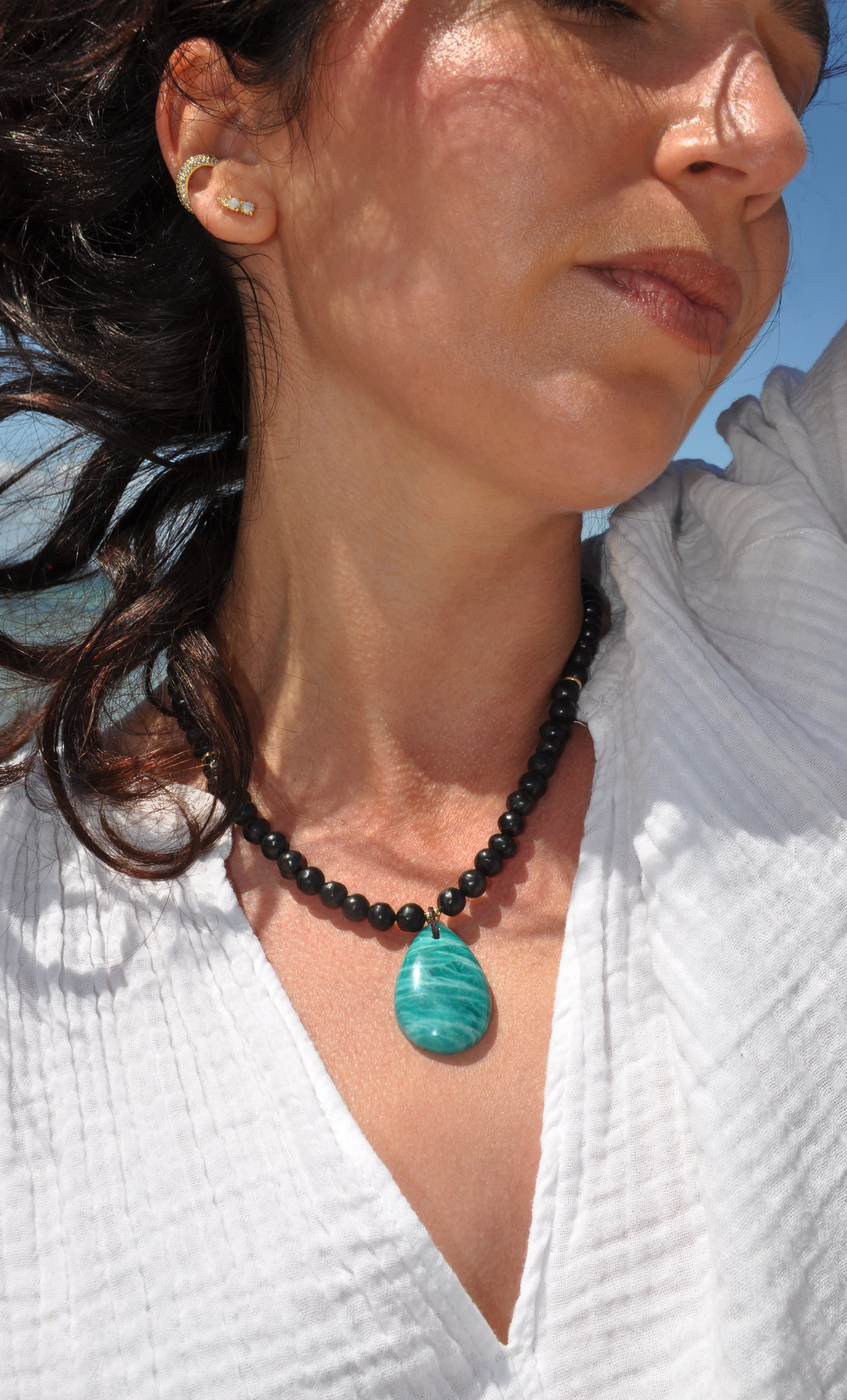 Tunik gold fill necklace featuring natural shungite pebble beads and AAA amazonite pendant on model.