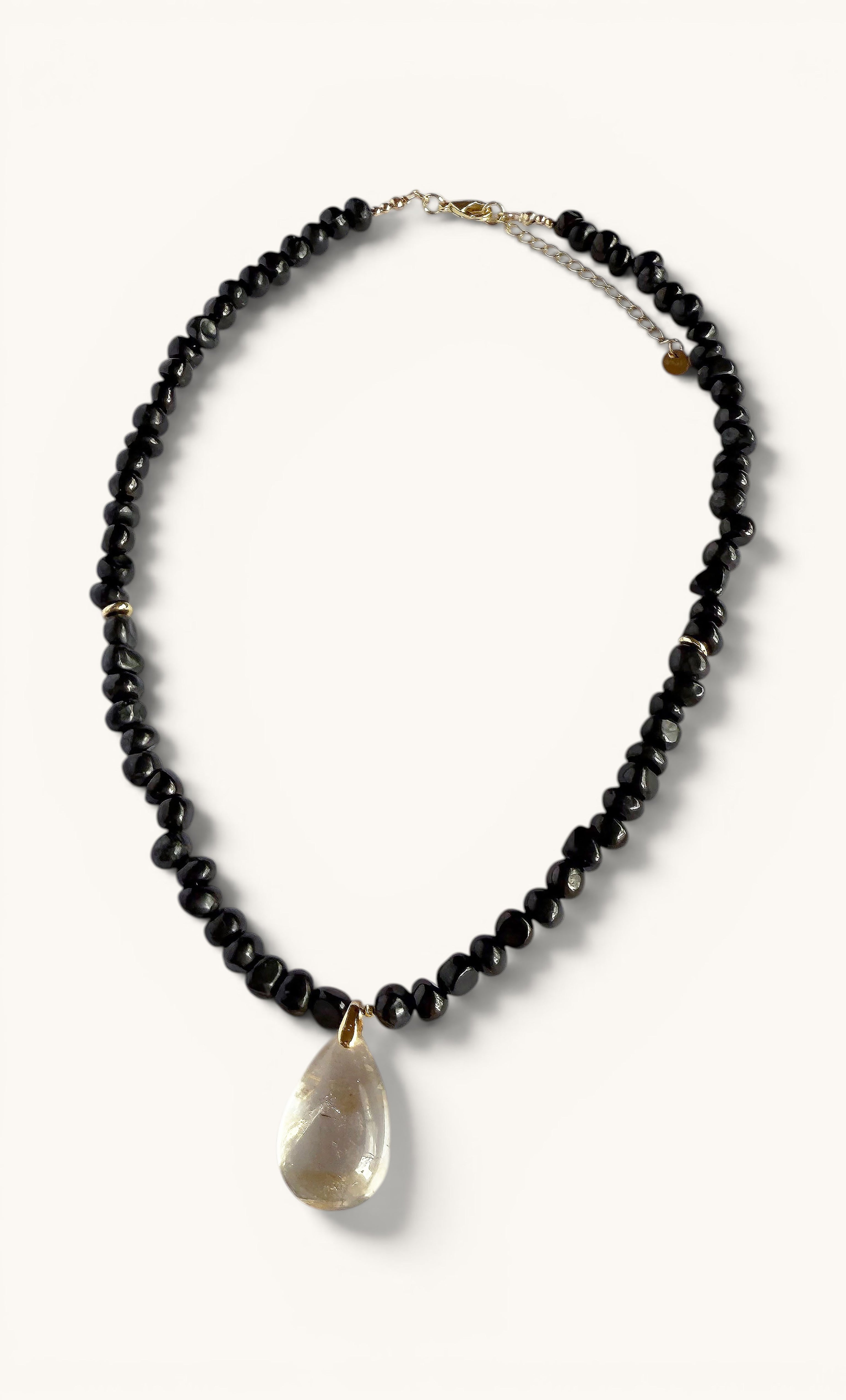 Black natural shungite pebble bead necklace with gold fill clasp and translucent citrine pendant.
