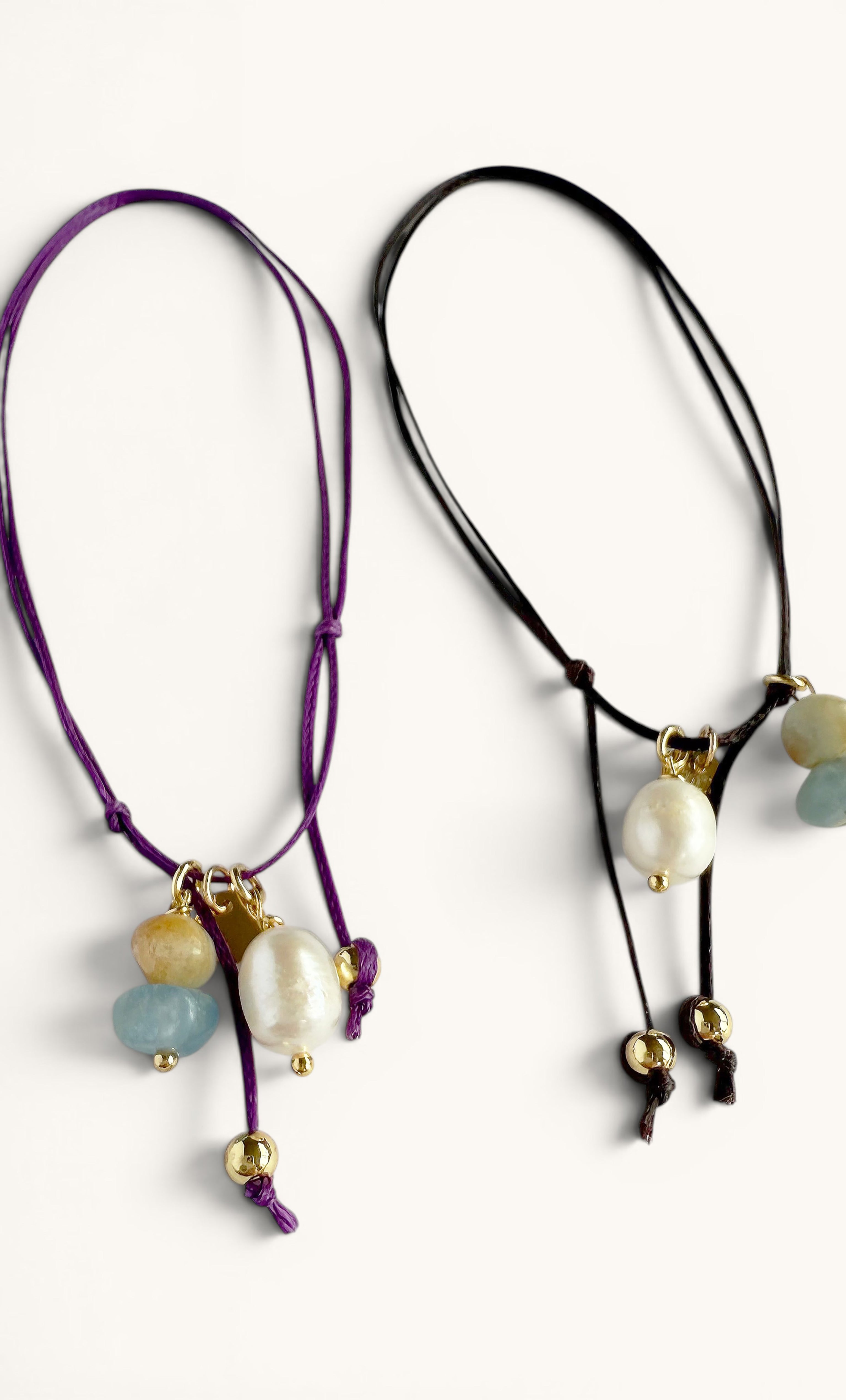 Handmade fine anklets with gold-filled beads, pearls, and deep purple and black cords, delicate charm details.