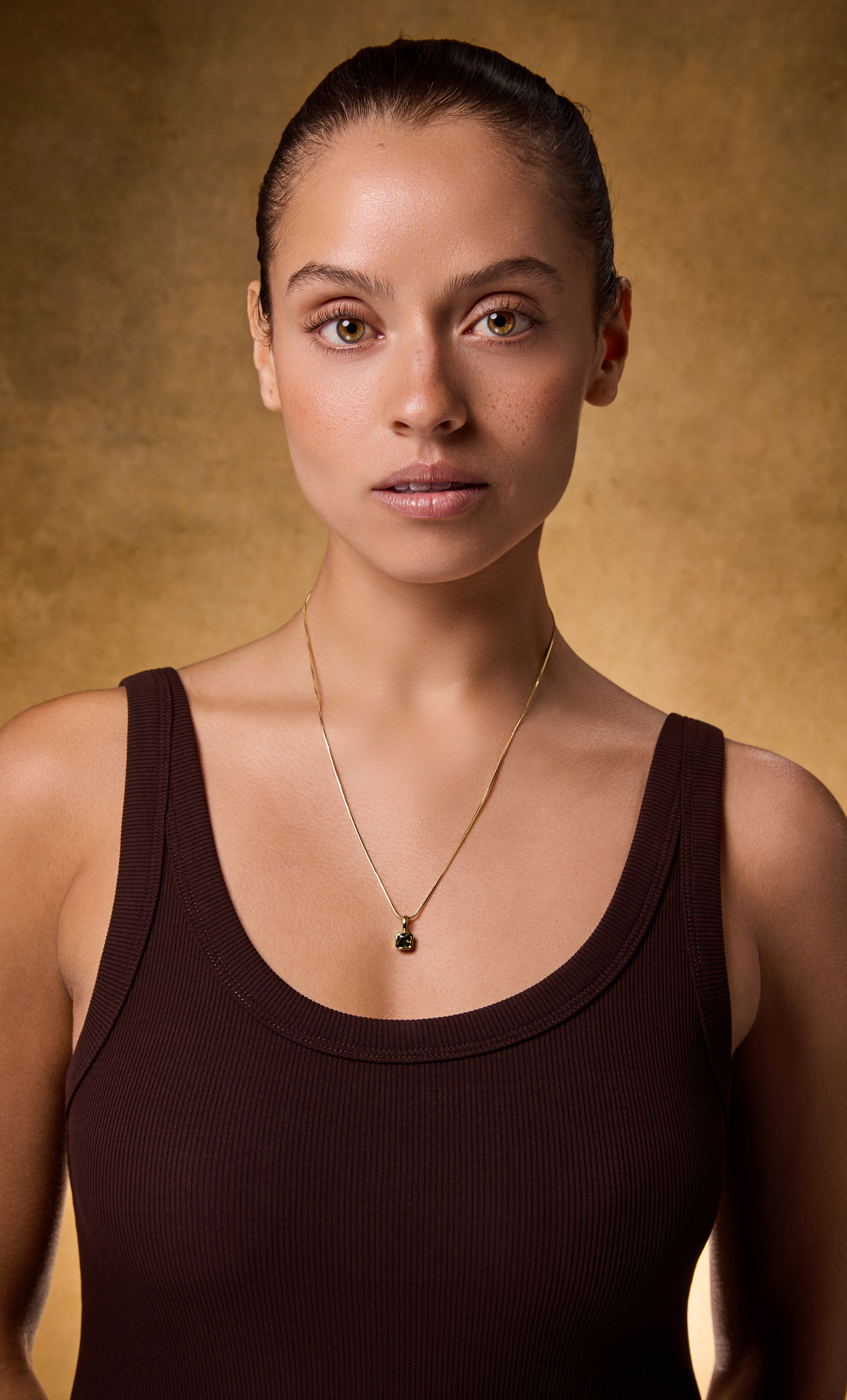 Tunik gold fill snake chain necklace with square pale yellow zirconia stone pendant on model.