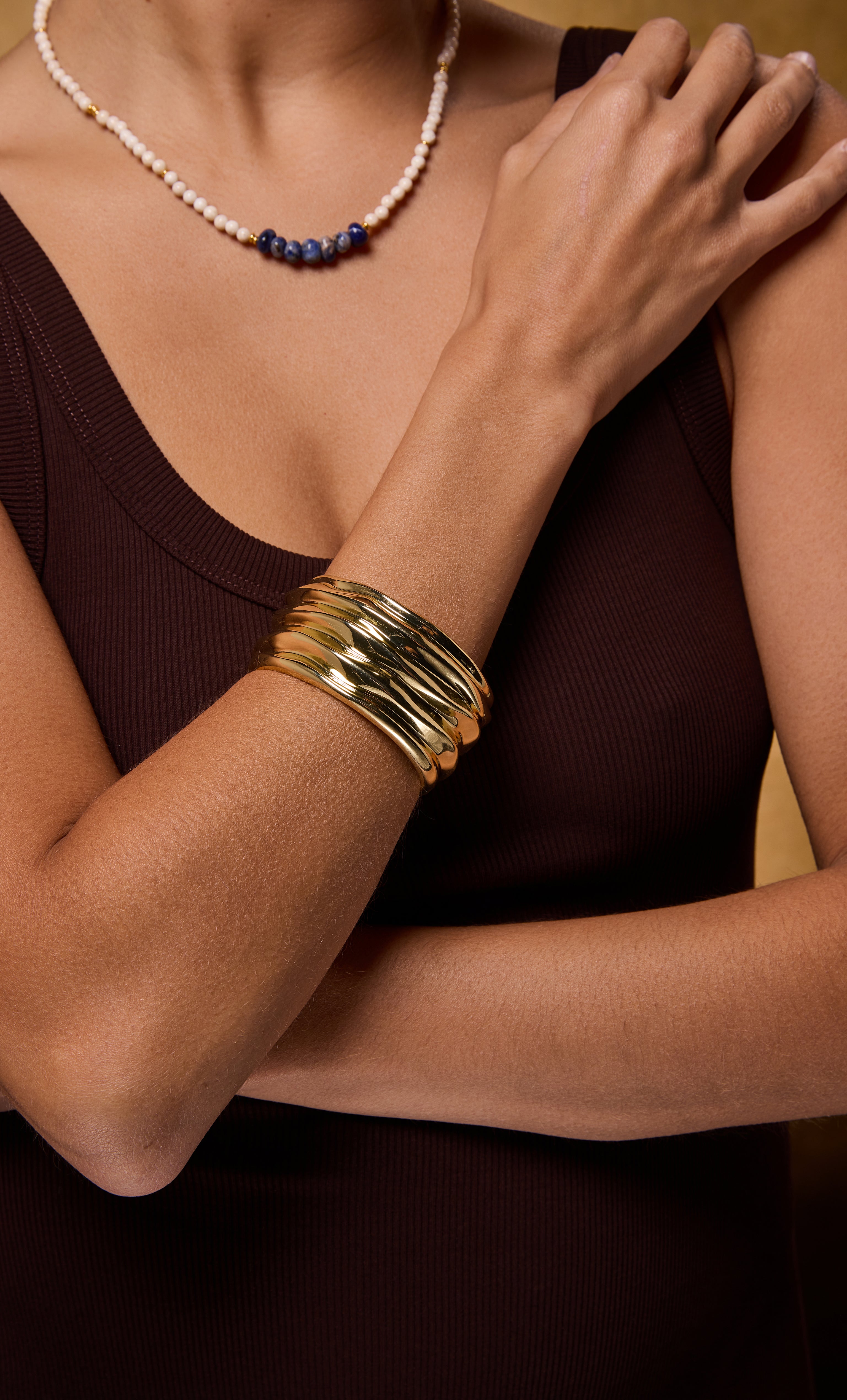 24K gold fill ripple cuff bangle bracelet by Tunik the label on wrist with layered gold necklace jewelry gifts.