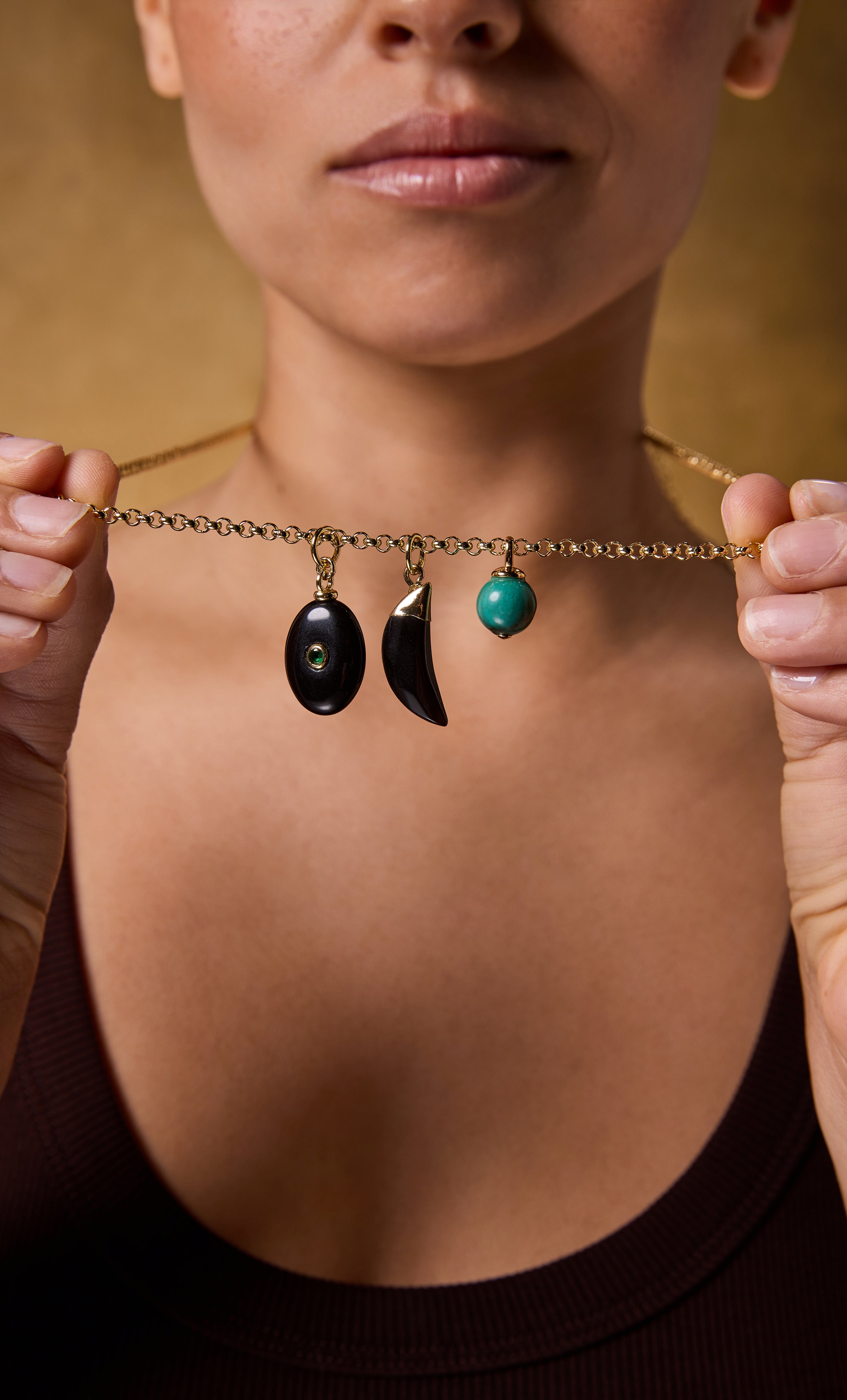 Tunik gold fill necklace with trio charms including black oval, crescent moon, and turquoise stone on rolo chain.