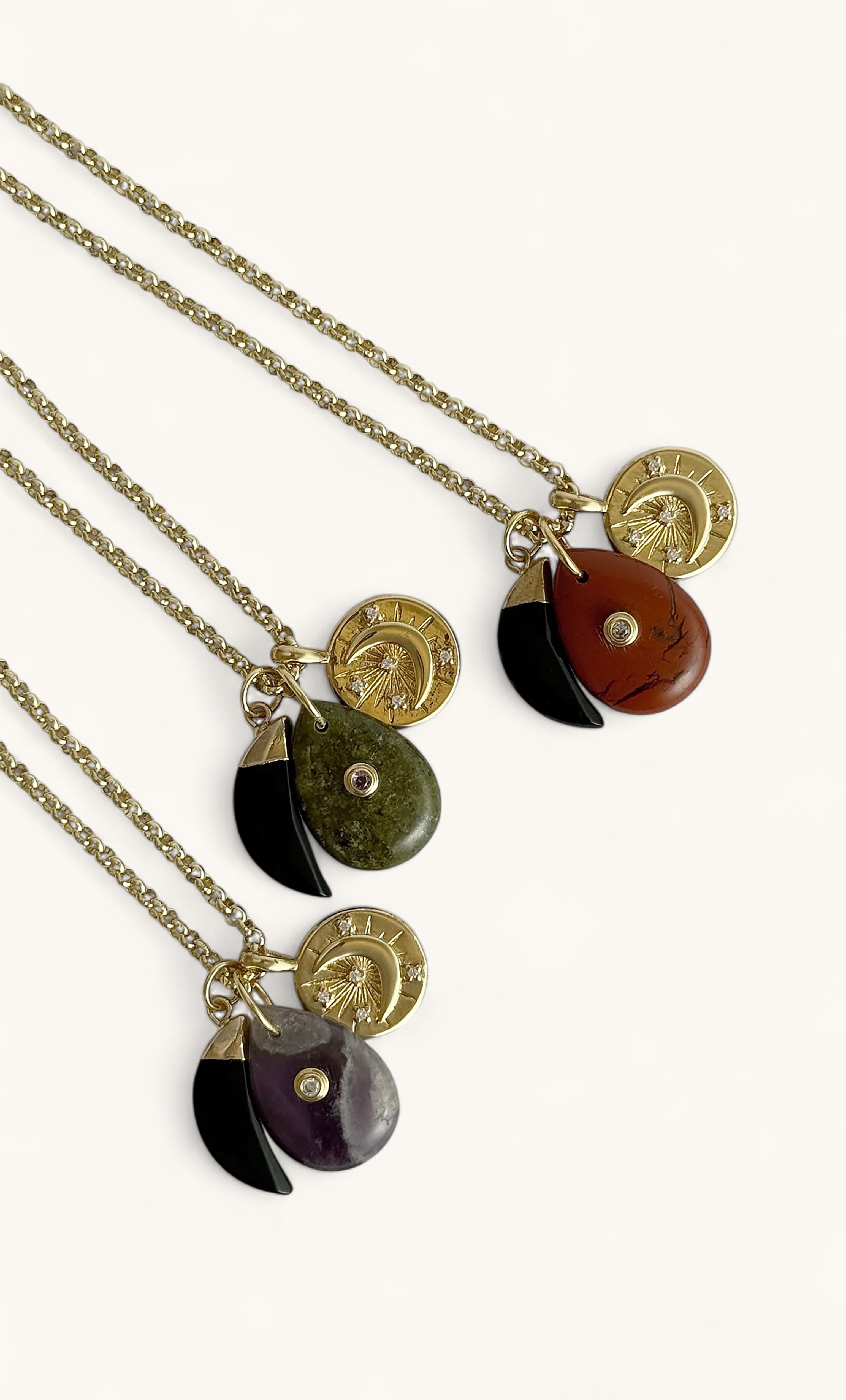 Three Tunik gold fill rolo chain necklaces with green, red, and purple opal charm pendants and gold label tags.