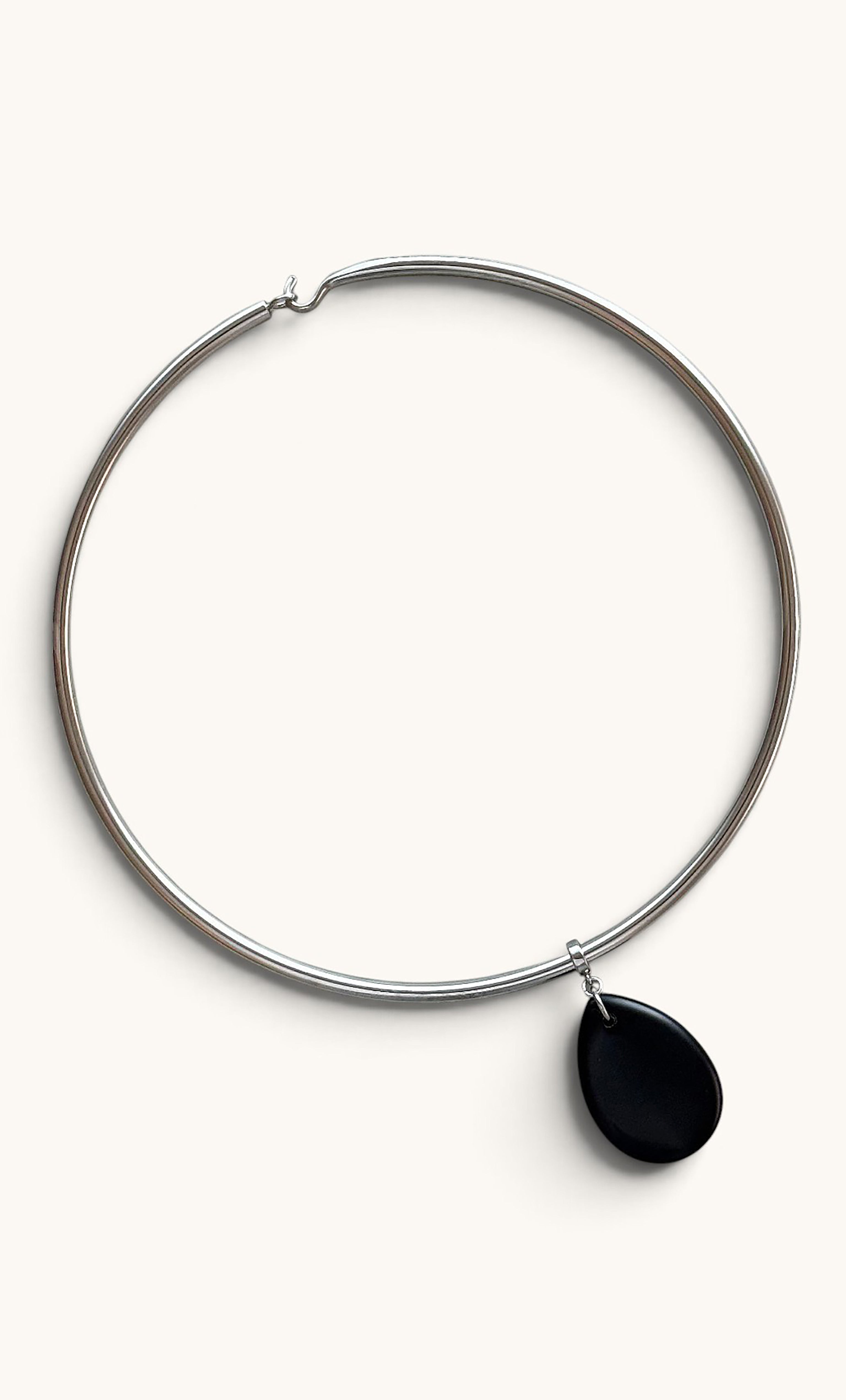 Silver collar necklace with smooth black agate teardrop pendant suspended center.