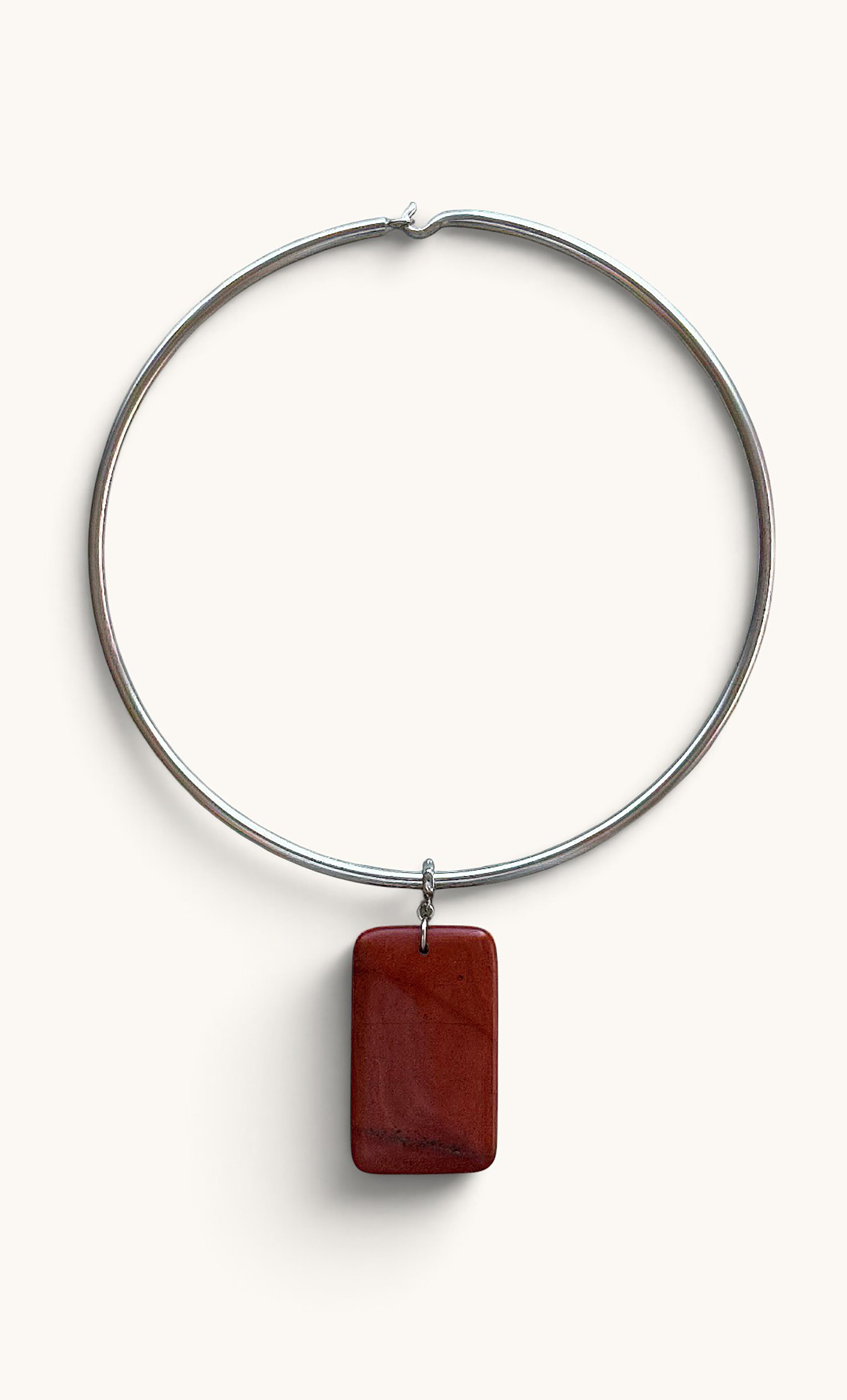 Silver collar necklace with smooth rectangular red jasper pendant.