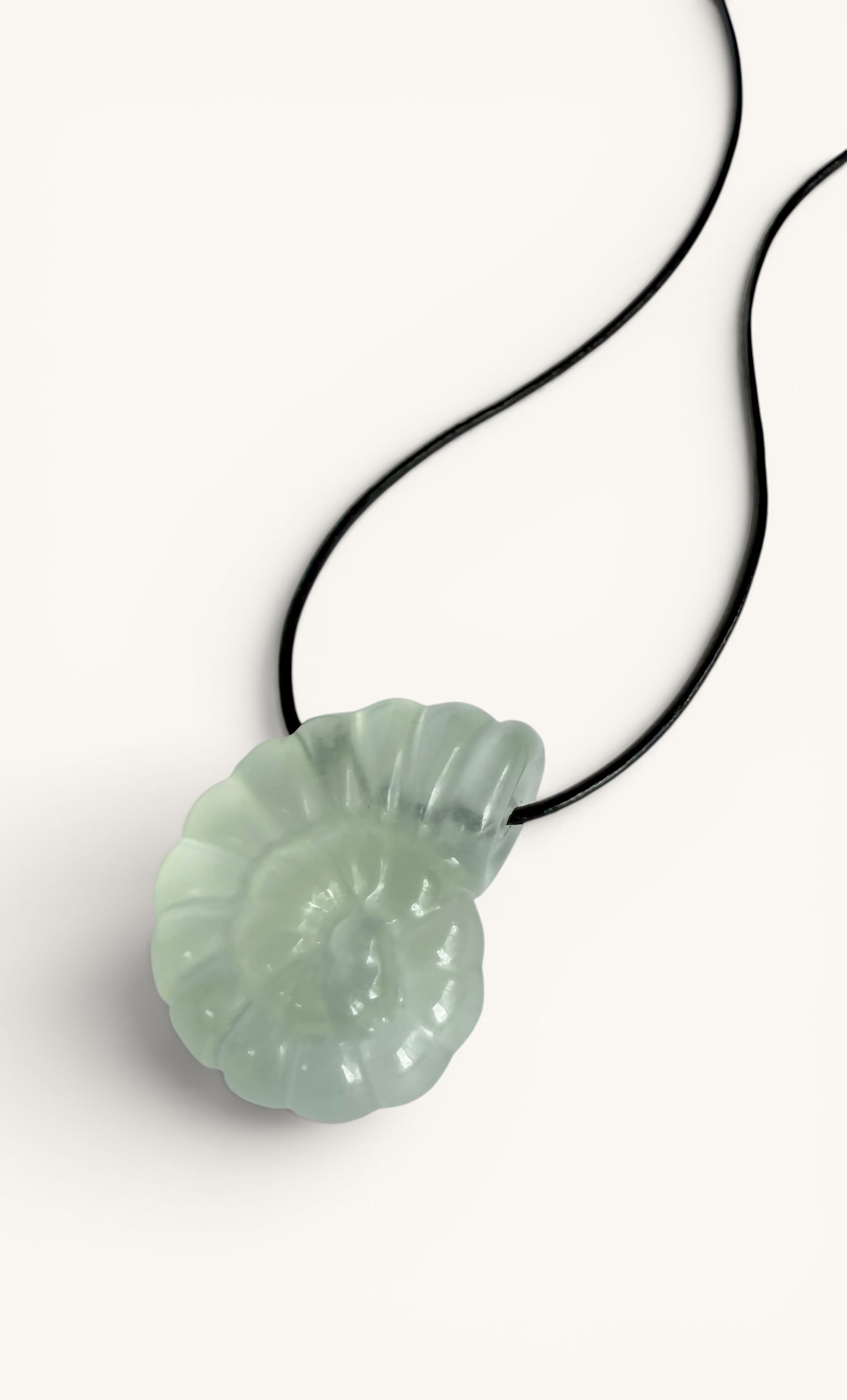 Green carved nautilus fluorite stone pendant on black cord necklace.