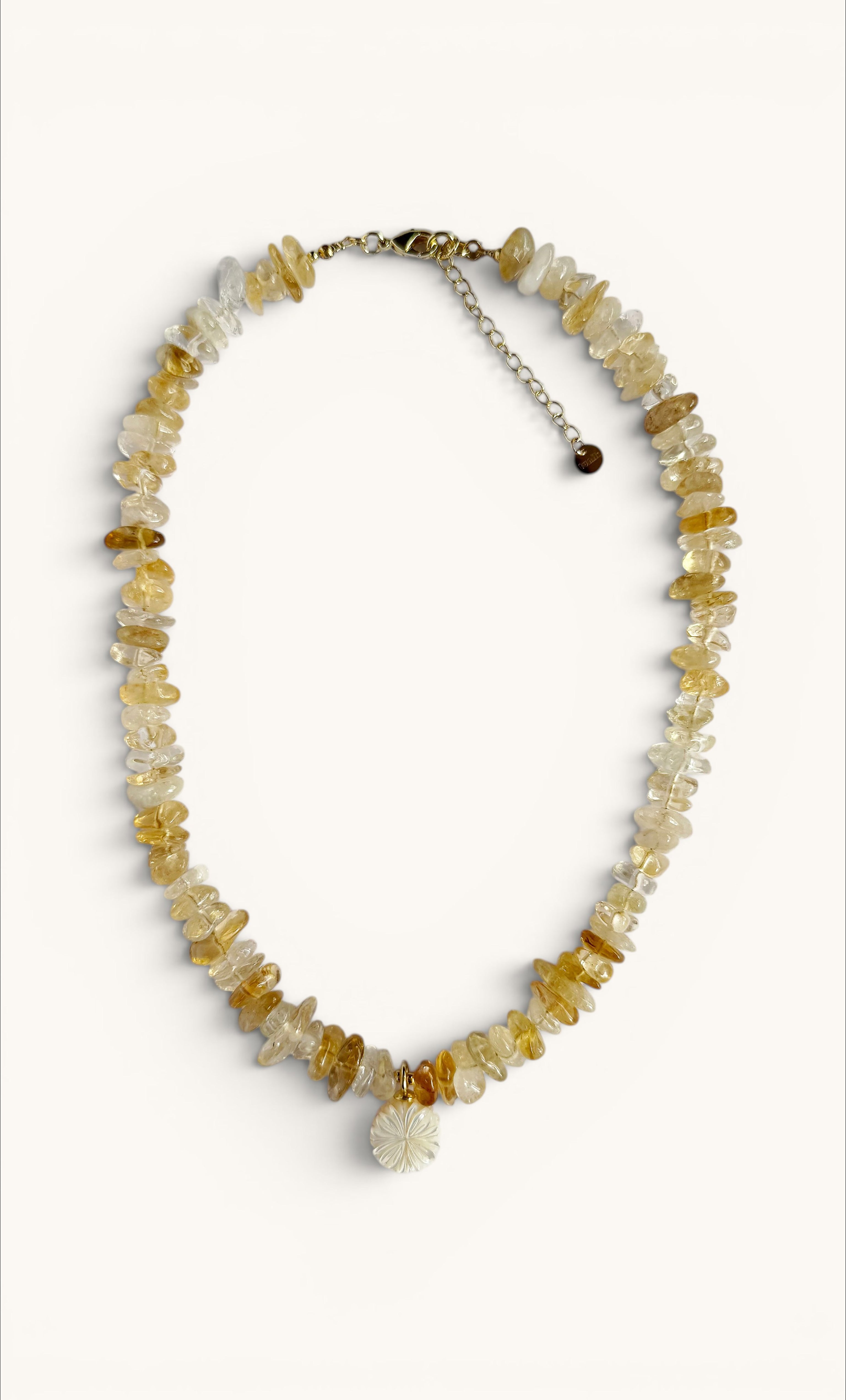 Handmade gold fill necklace with irregular yellow citrine stones and carved flower-shaped pendant.