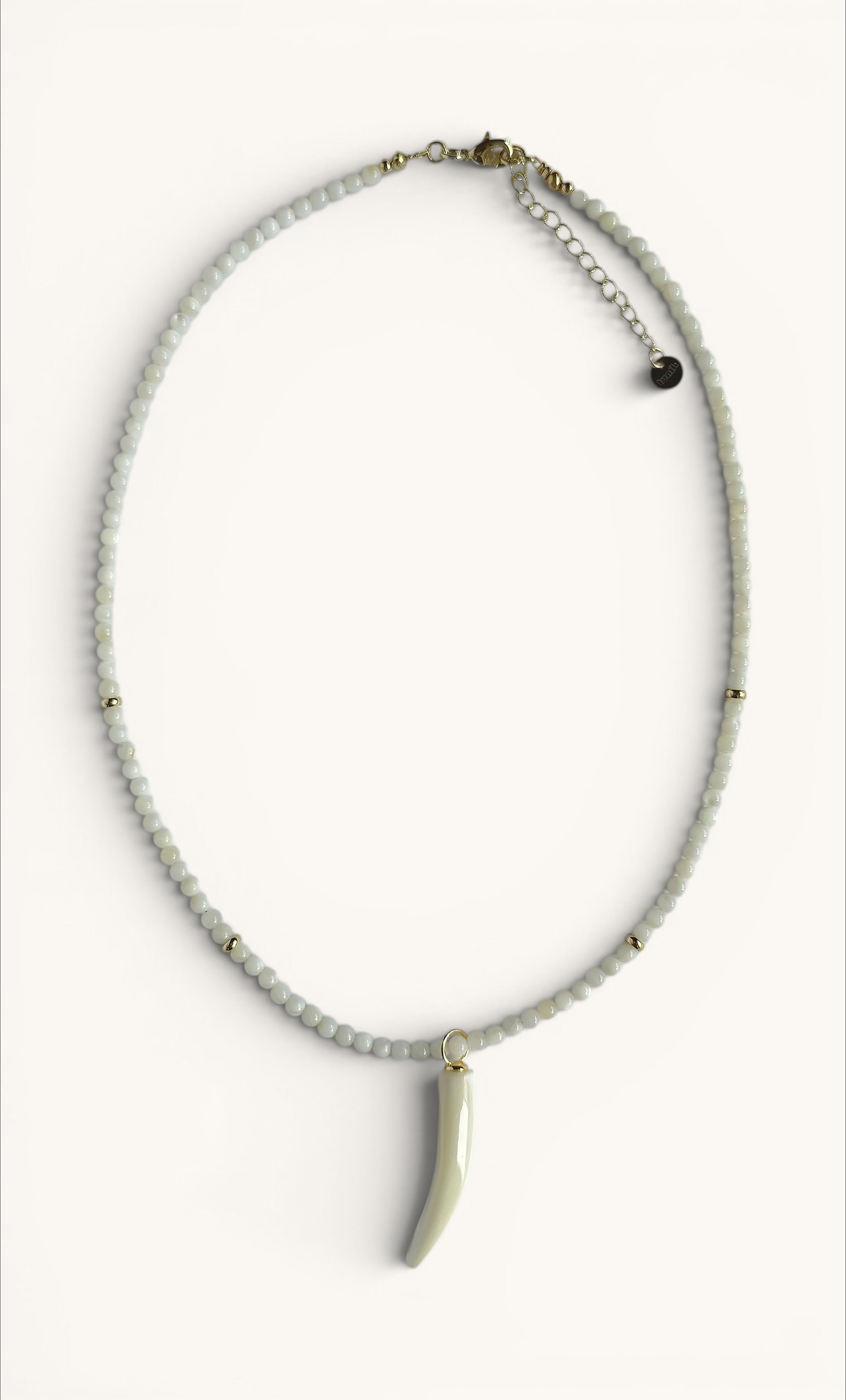 Delicate hand-beaded necklace with small white beads and a carved mother of pearl horn pendant, gold fill clasp.