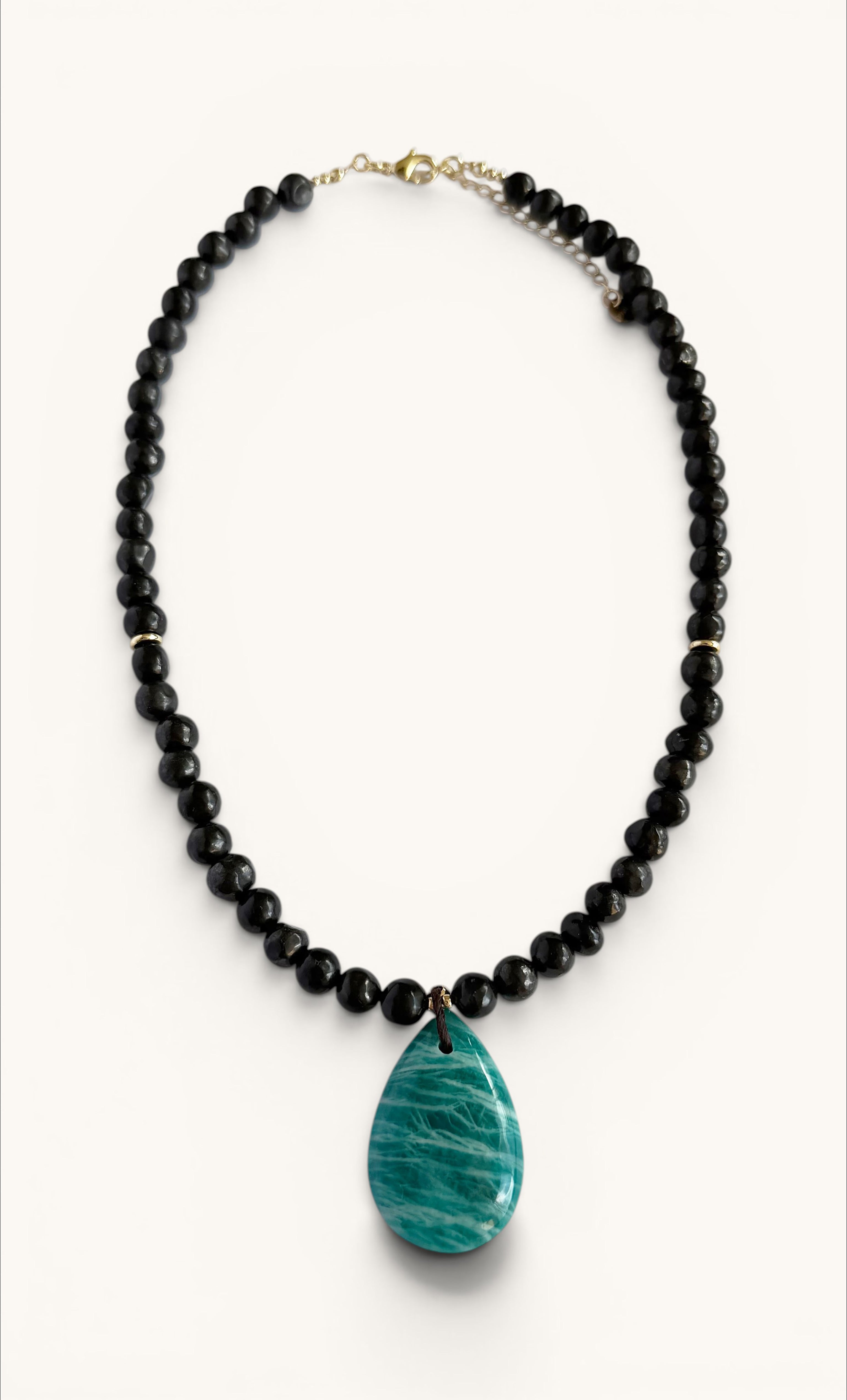 Gold-filled necklace with black shungite pebble beads and a large teardrop-shaped blue amazonite pendant.