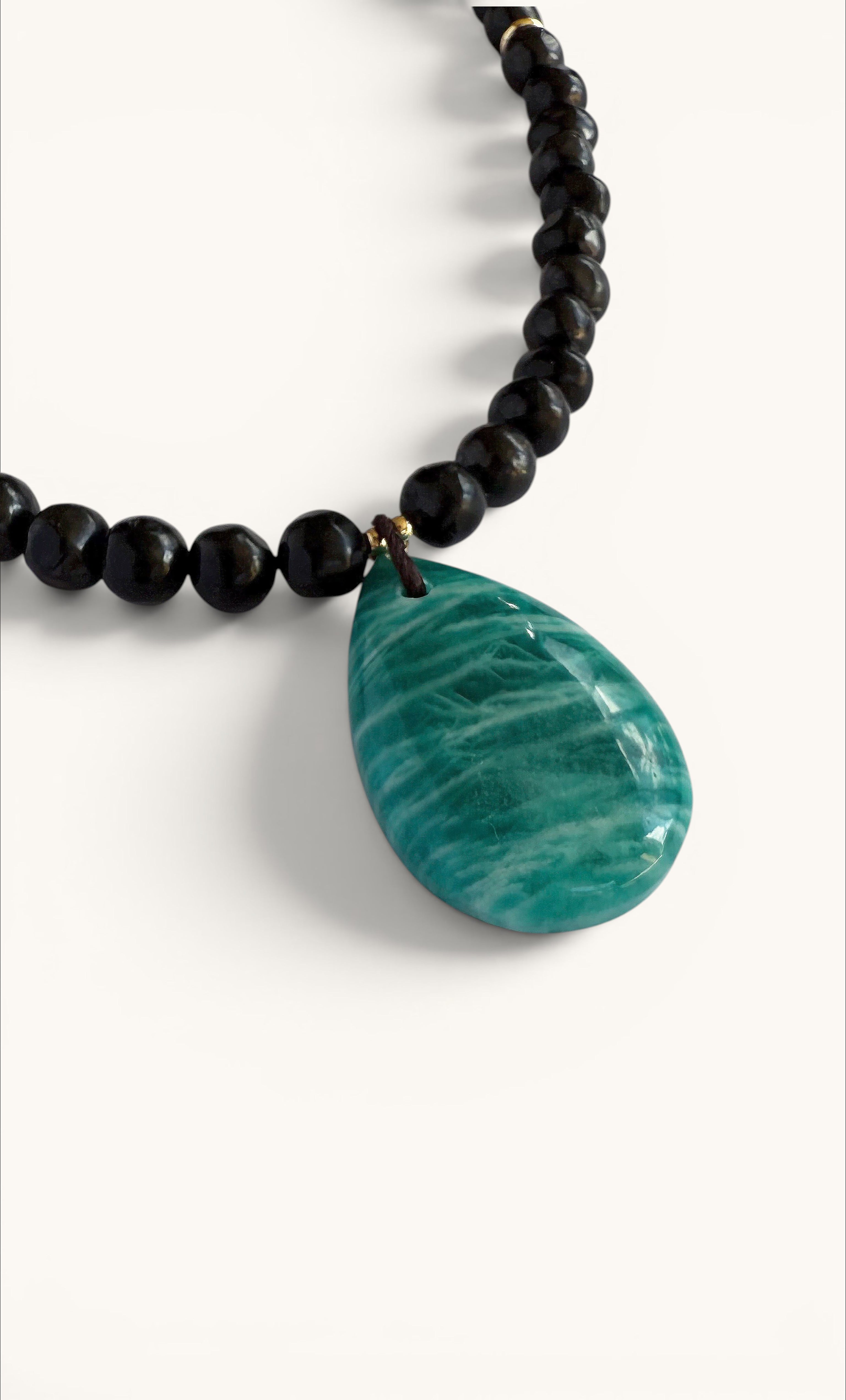 Gold fill necklace with black shungite pebble beads and a teardrop-shaped natural amazonite pendant.