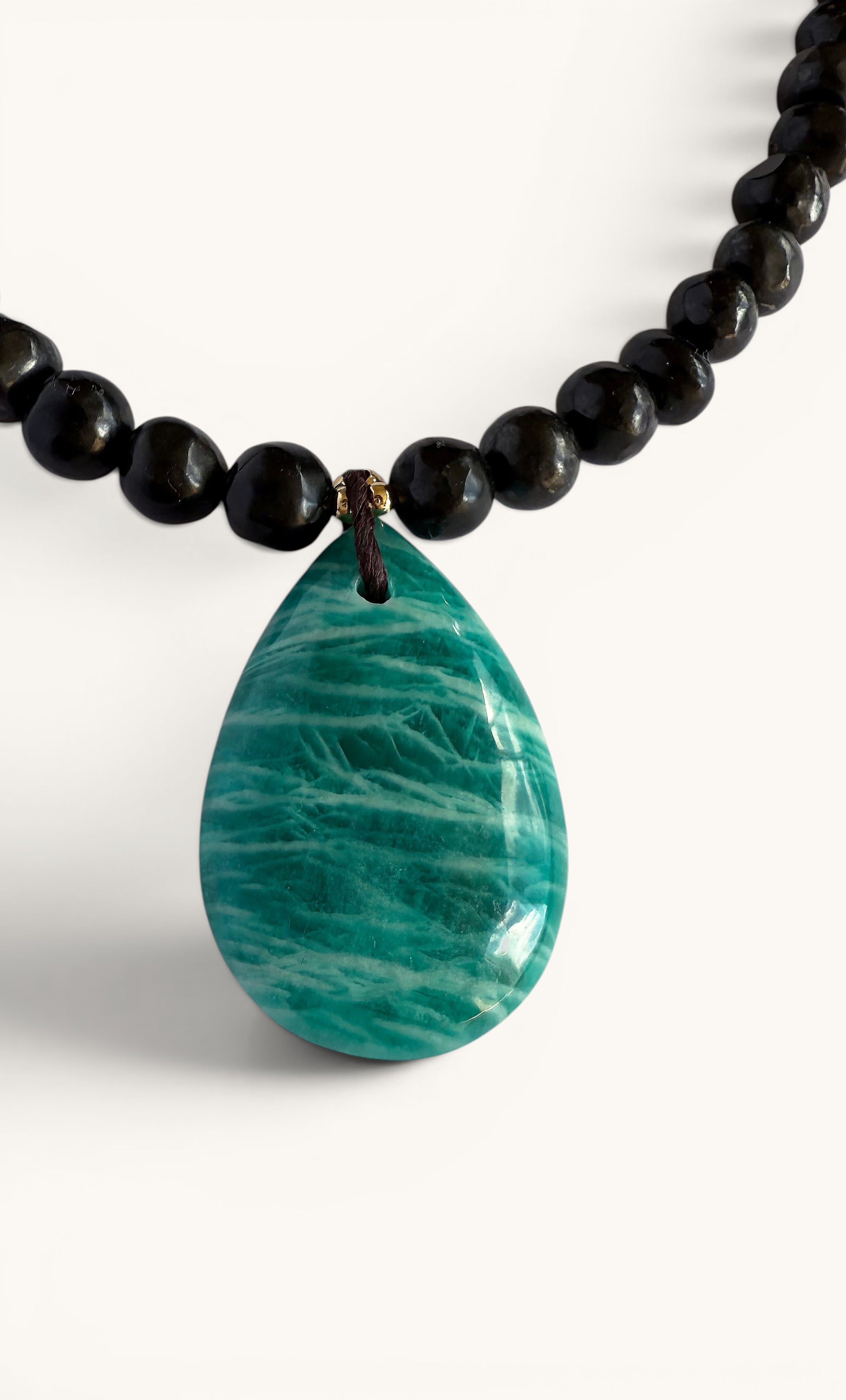 Gold-fill necklace with glossy black shungite beads and a large teardrop-shaped natural amazonite pendant.