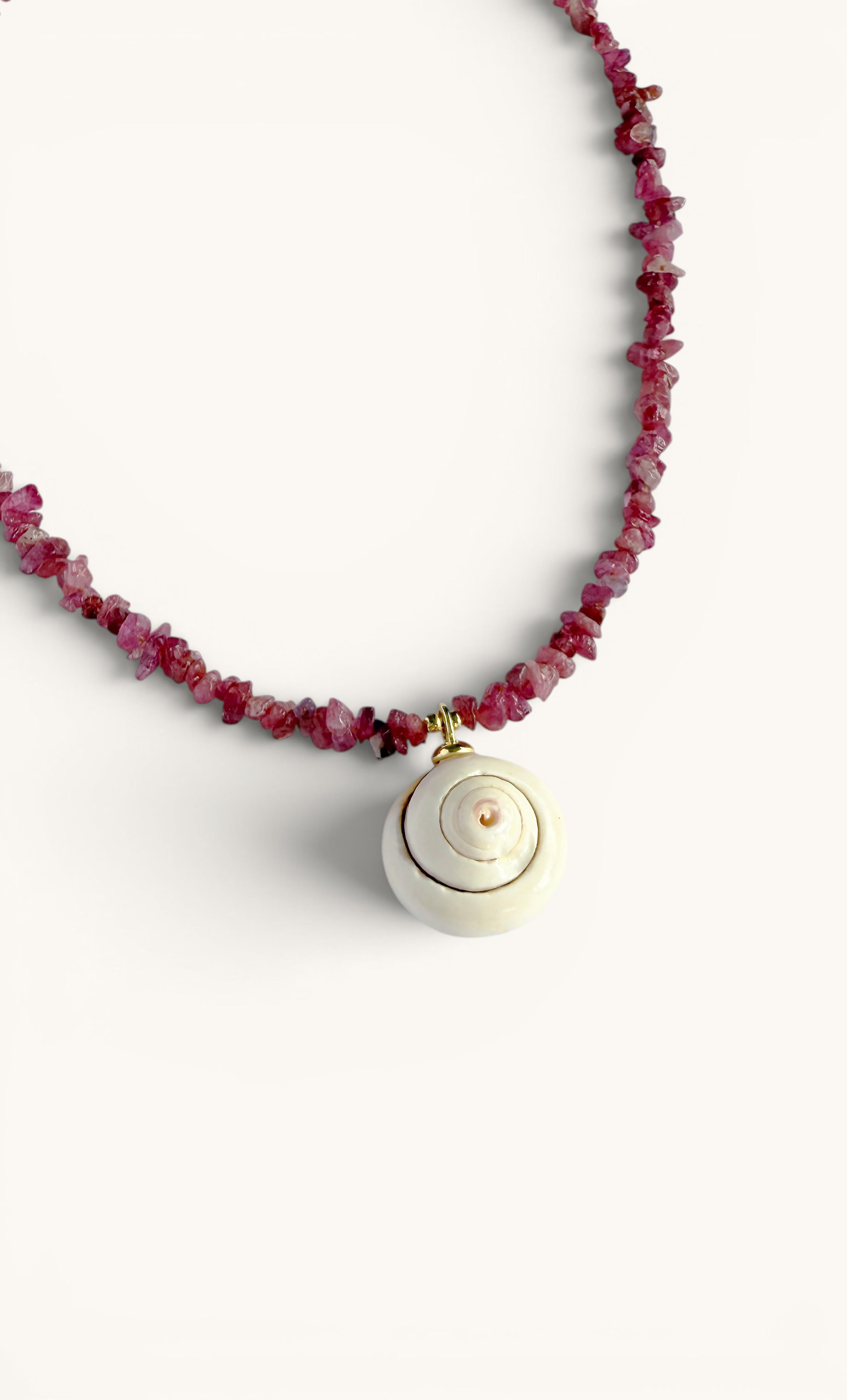 Gold-filled shell charm pendant on hand-beaded pink tourmaline stone necklace by Tunik.