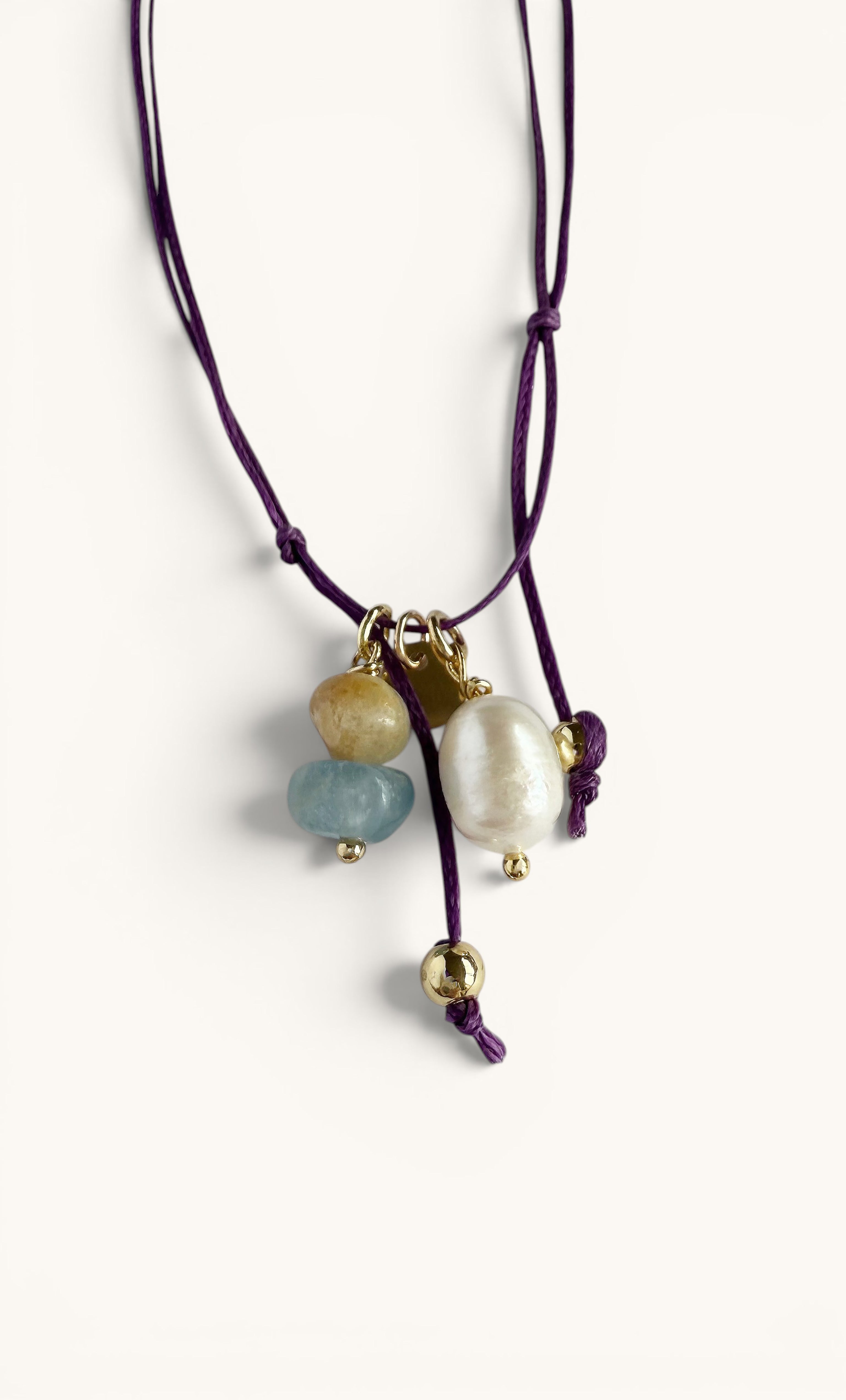 Deep purple cord anklet with gold-filled chains, featuring blue and white pearl charms.