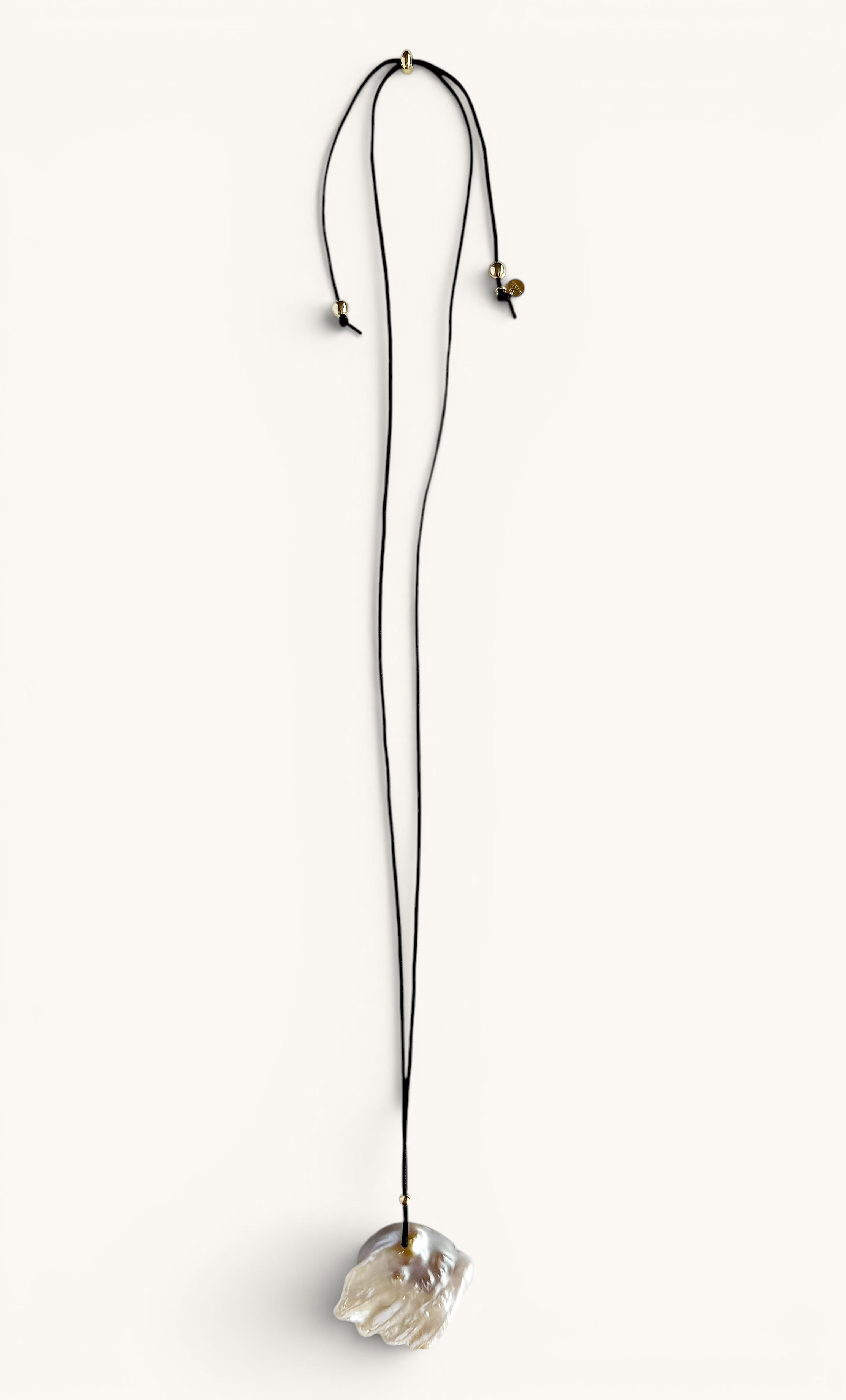 Long gold fill necklace with irregular freshwater blister pearl pendant on adjustable thin chain.