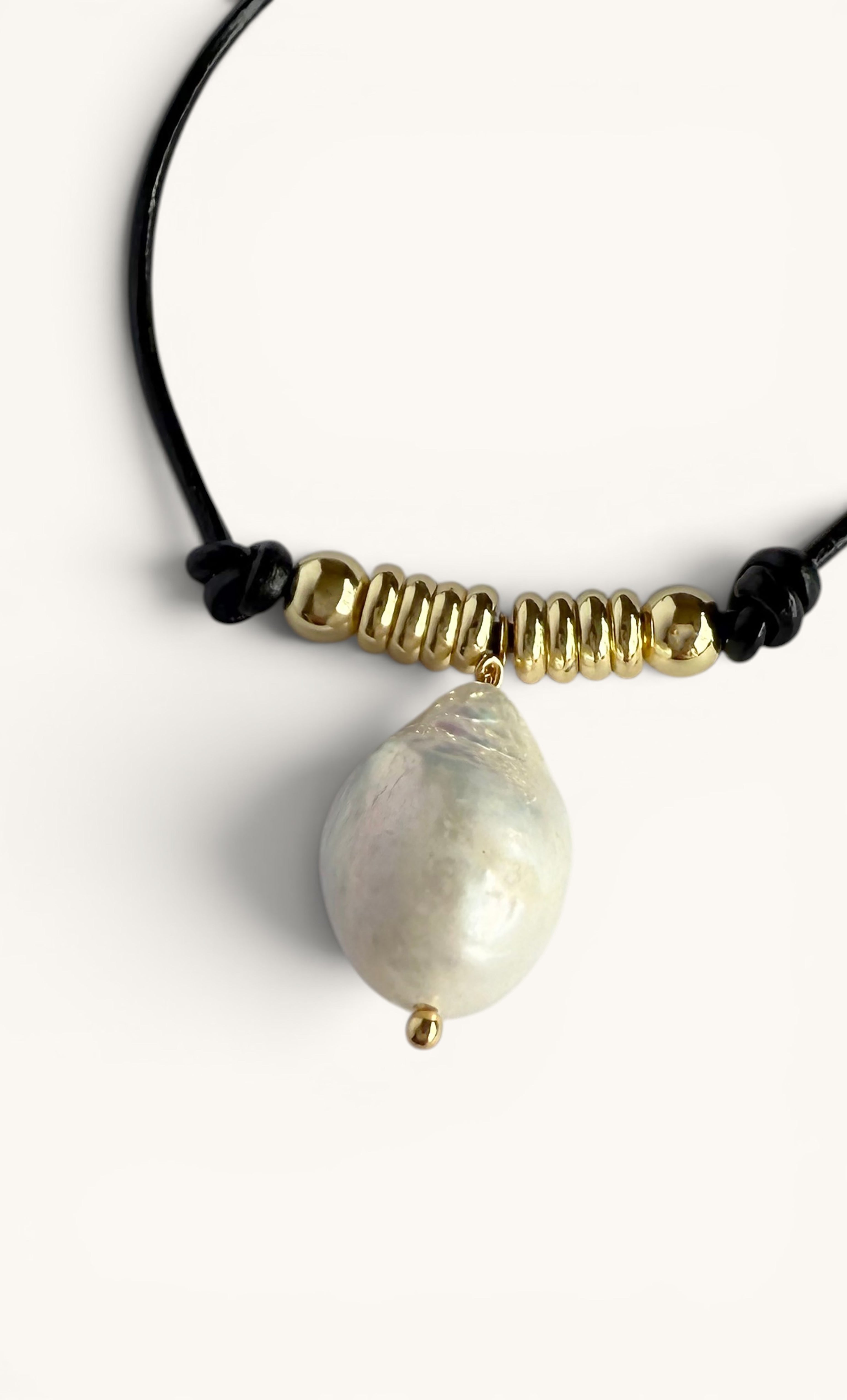 Black leather bracelet with baroque pearl pendant and 24K gold fill bead accents.