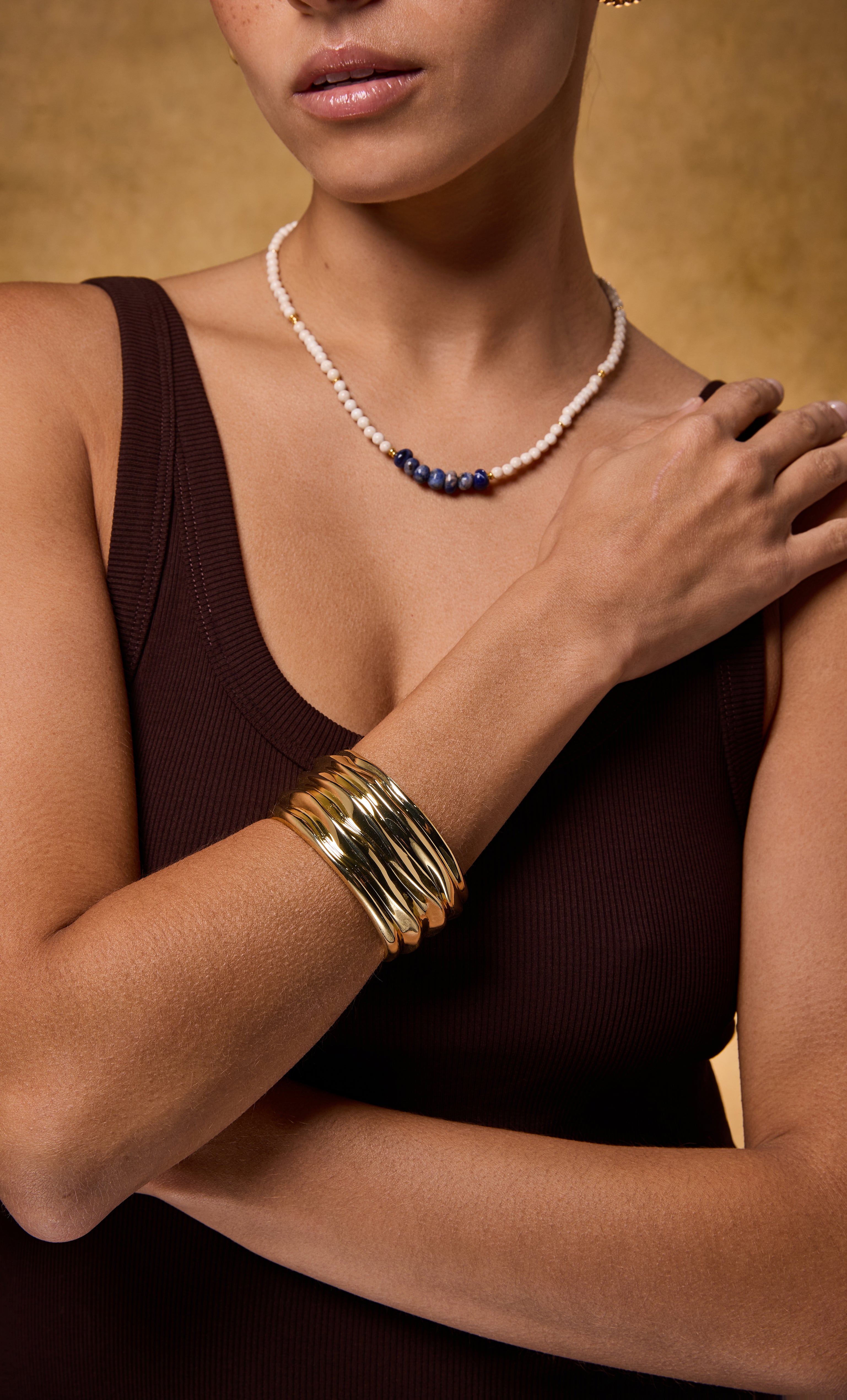 24K gold fill ripple cuff bangle bracelet by Tunik, layered with delicate gold necklace, styled as jewellery gift.