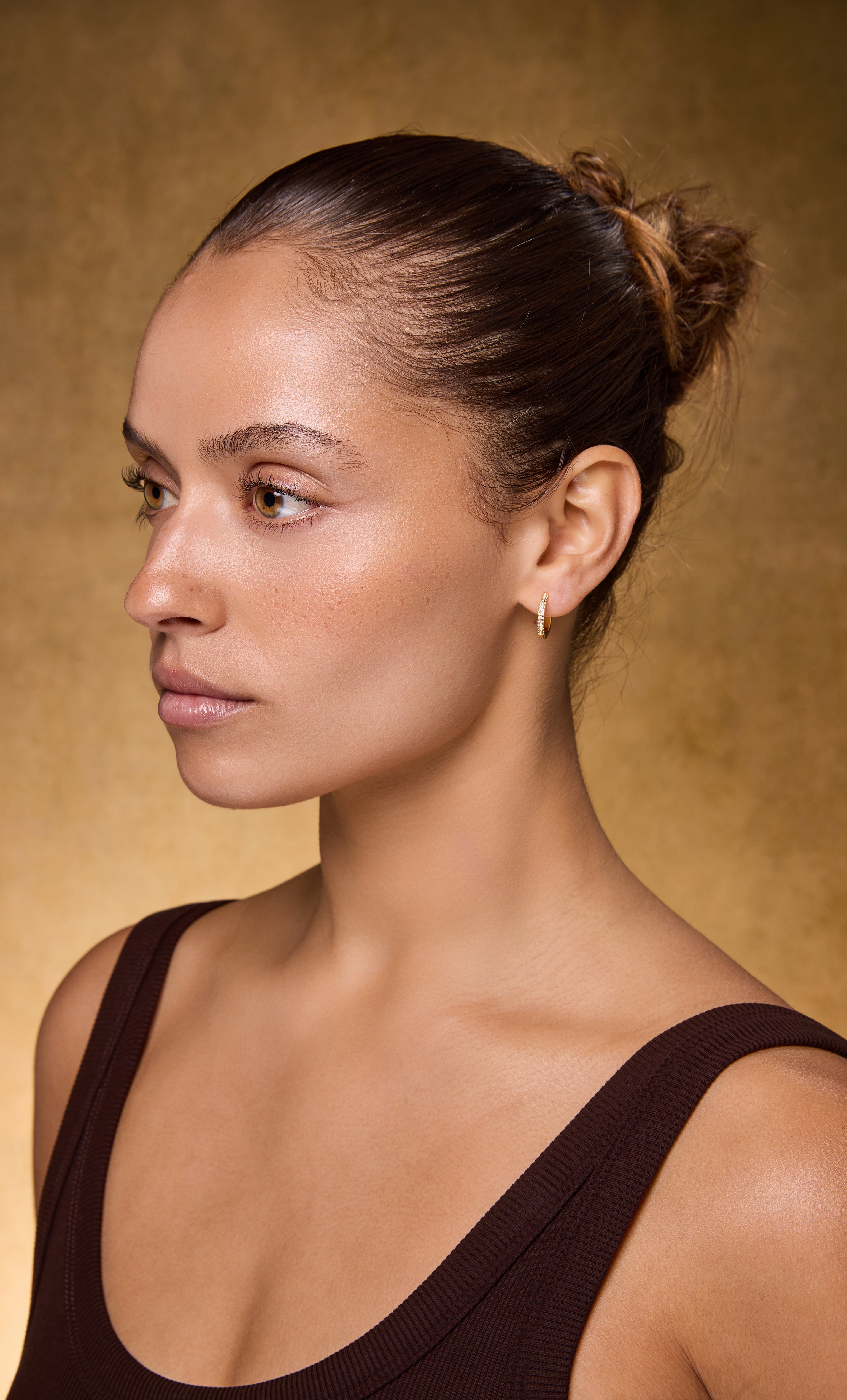 Tunik Gaia 24K gold fill huggie earrings with clear zirconia stones worn with gold necklace jewelry gifts.