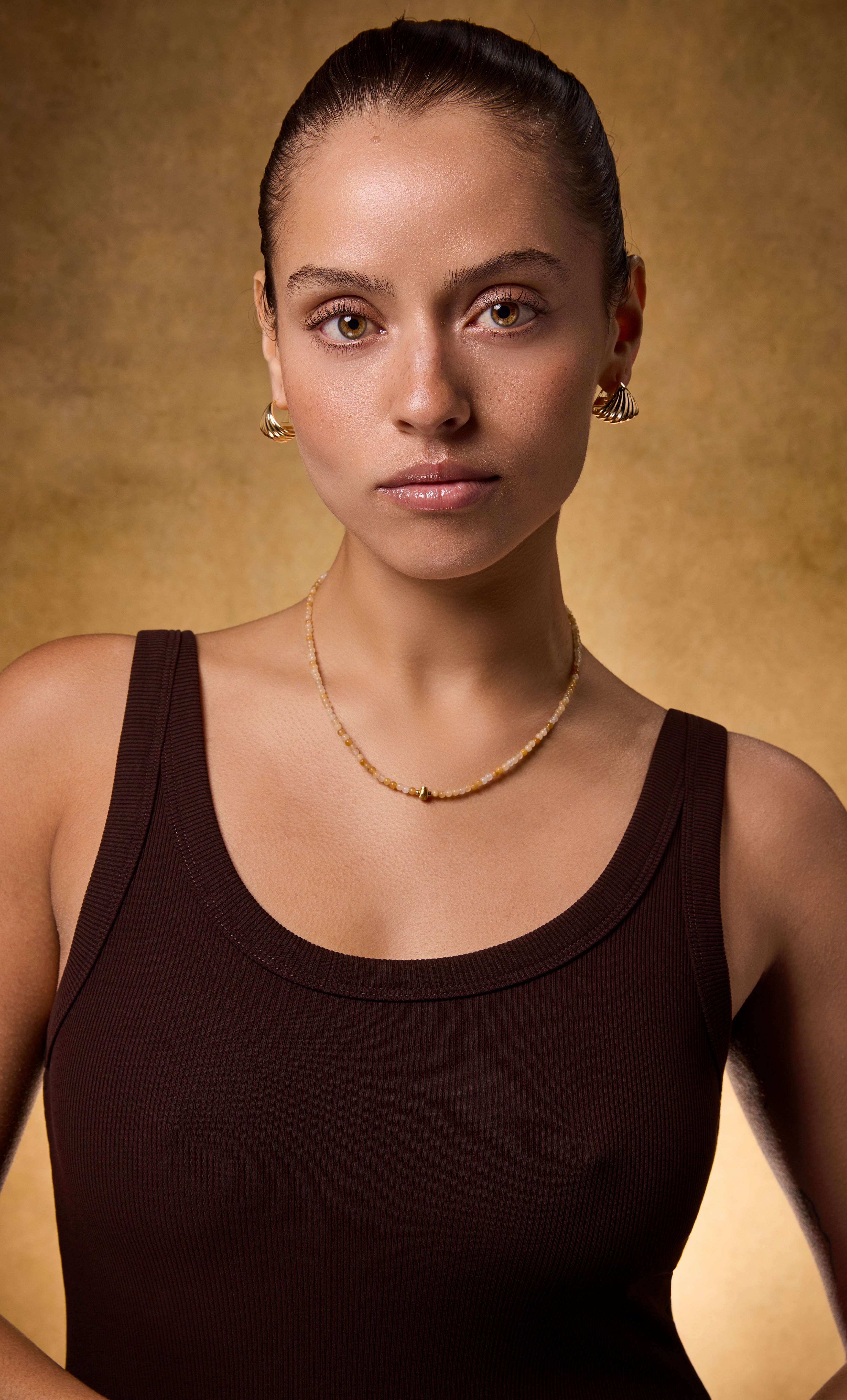 Delicate gold fill necklace by Tunik featuring yellow jasper ombre beads, styled with simple gold hoop earrings.