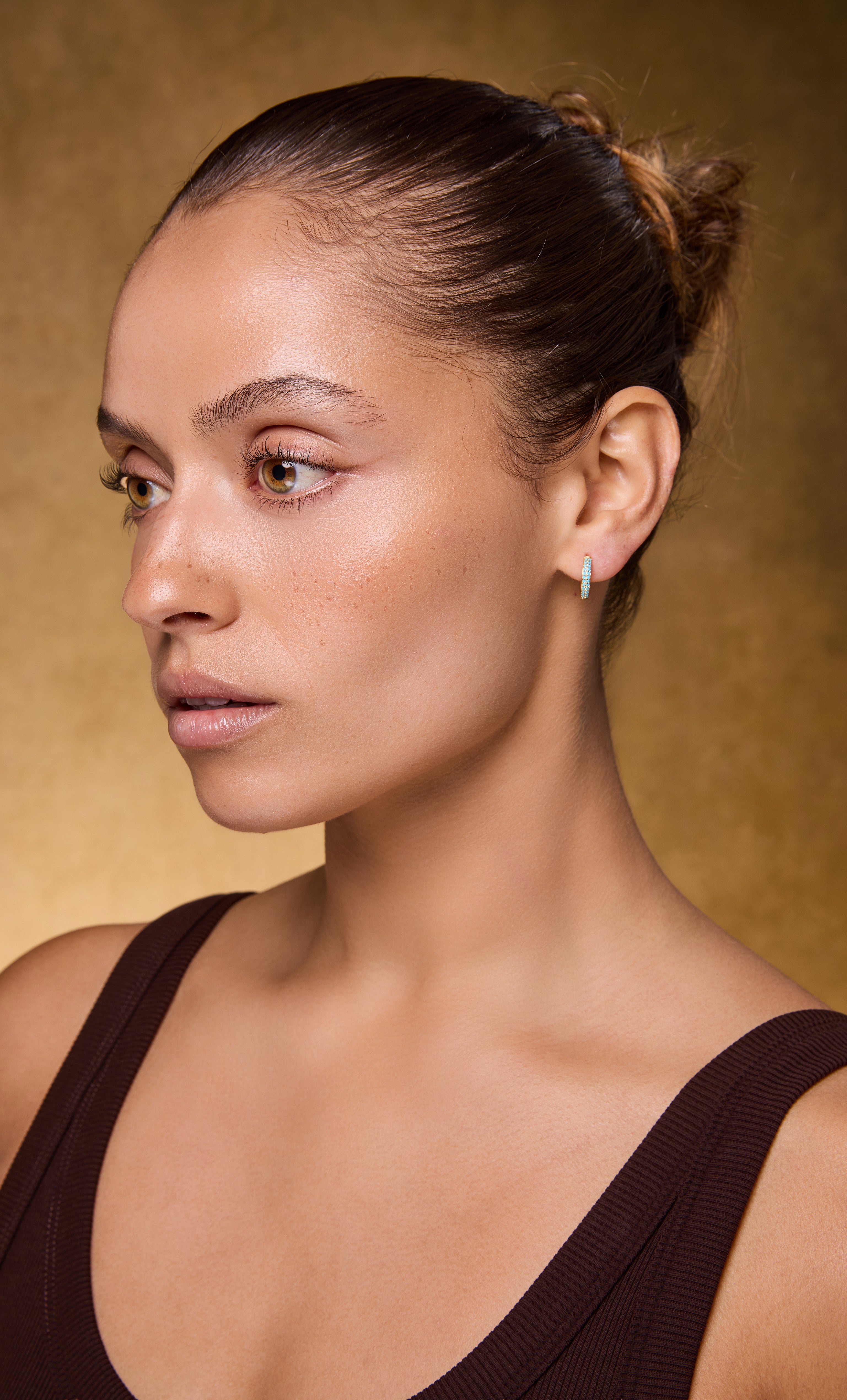 Tunik gold fill huggie earrings with turquoise zirconia stones worn with gold necklace, jewellery gifts.