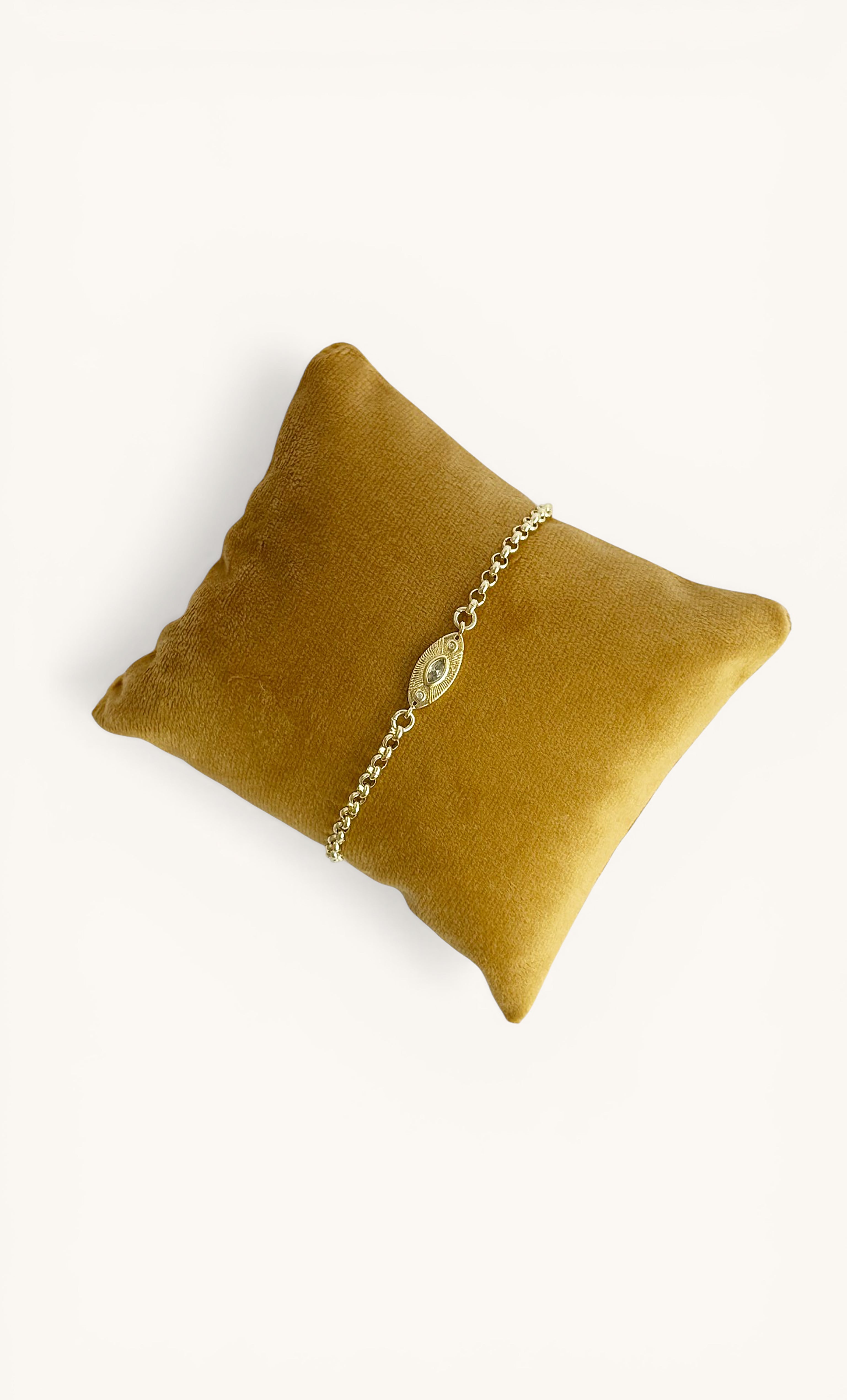 Gold fill rolo chain bracelet with oval charm displayed on mustard velvet cushion, Tunik jewellery gifts.