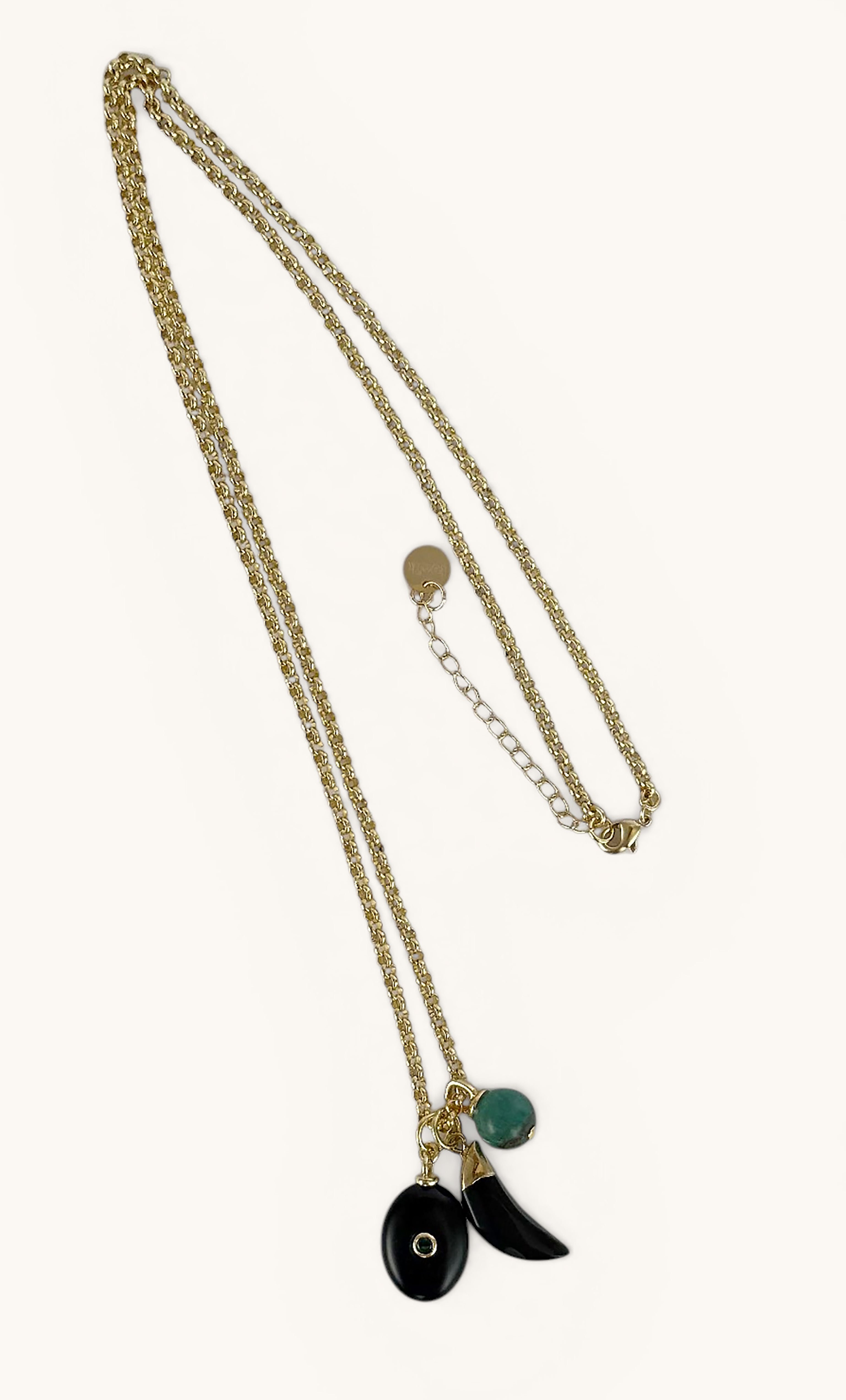 Long 24K gold fill rolo chain necklace by Tunik with three distinctive charms, including black and turquoise details,.