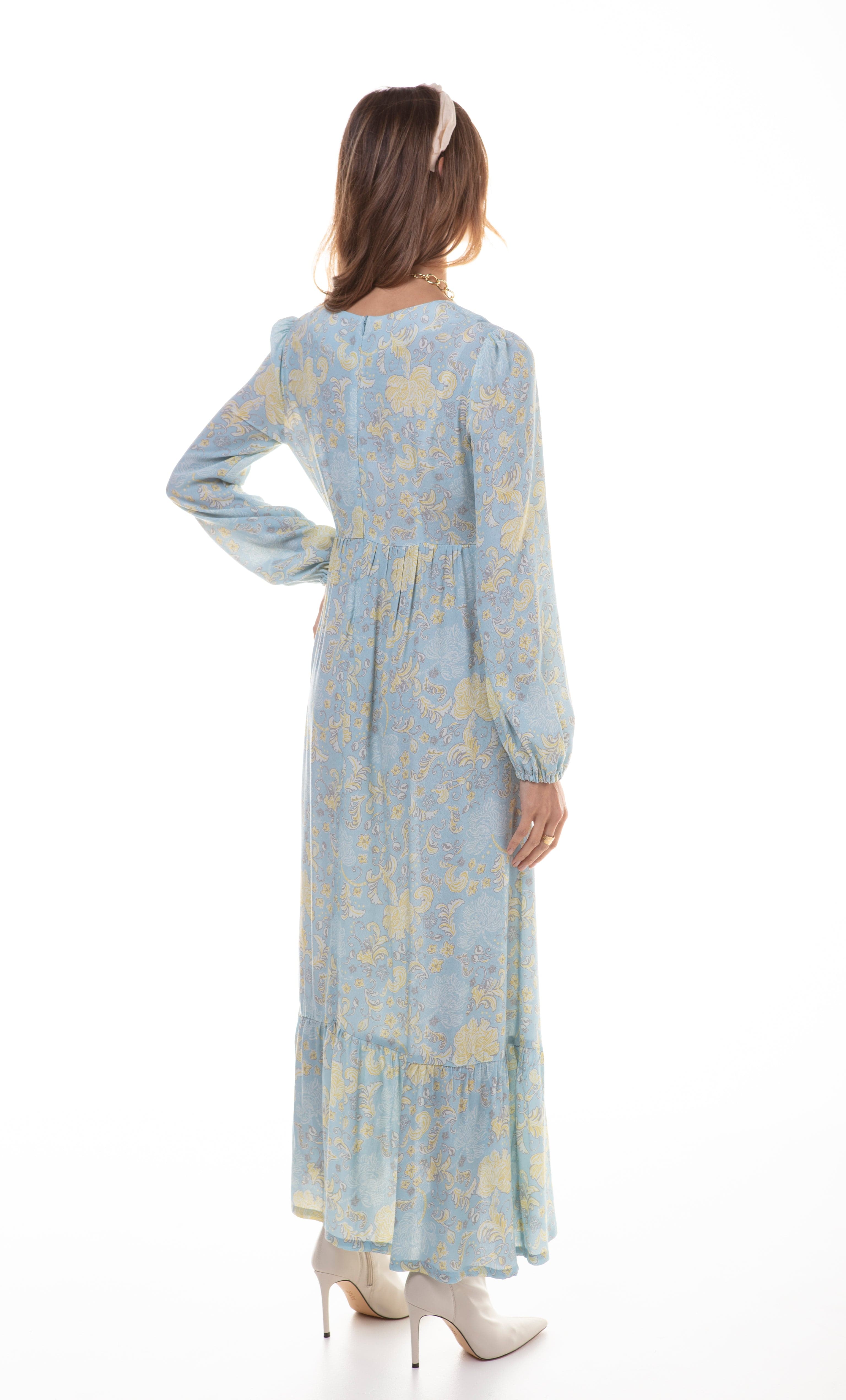 Tunik Lola maxi dress in Mystic Floral Aquamarine print with long sleeves and tiered skirt, styled with gold fill necklace.